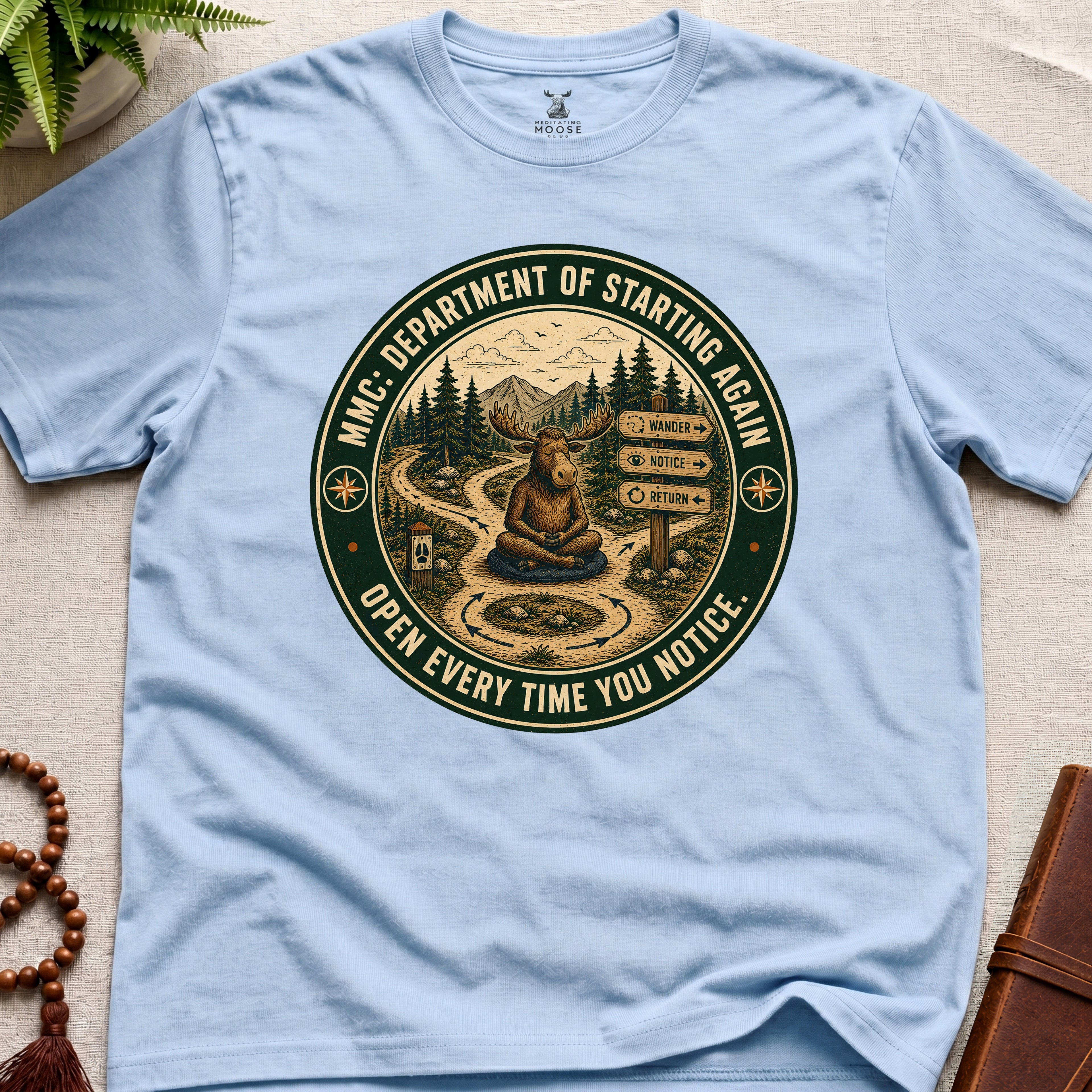 Light blue funny mindfulness t-shirt mockup featuring Meditating Moose Club Department of Starting Again moose graphic