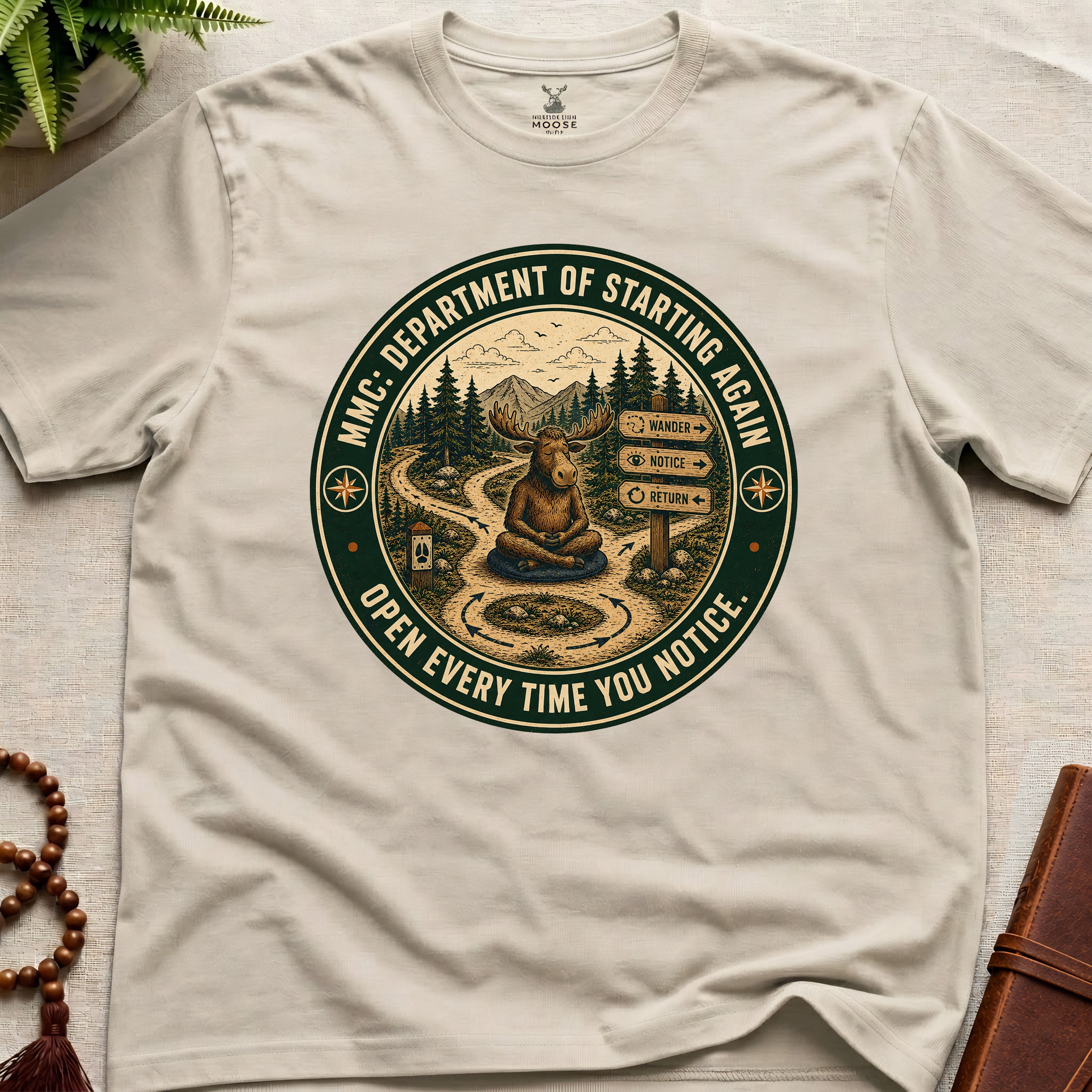Beige funny mindfulness t-shirt mockup featuring Meditating Moose Club Department of Starting Again moose graphic