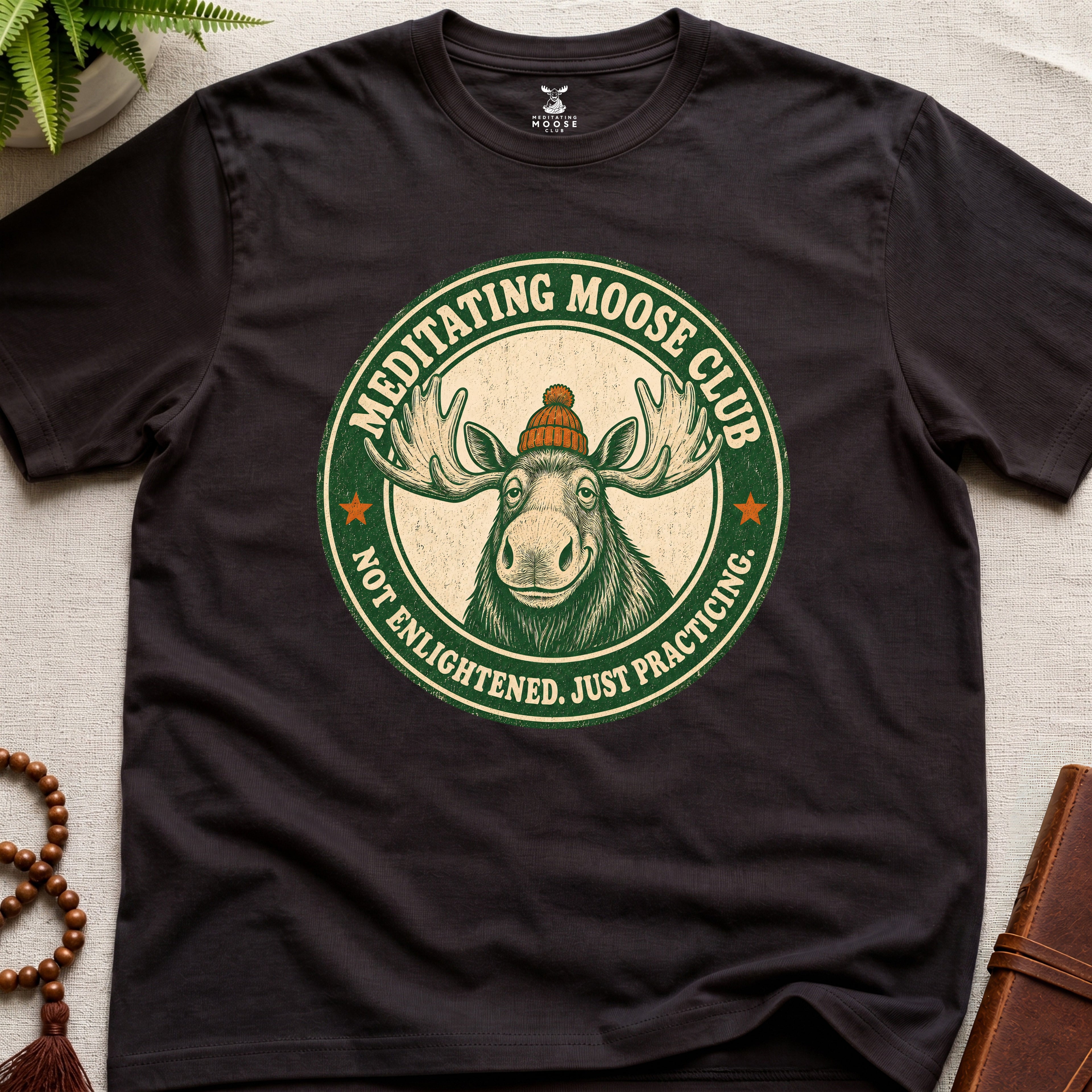 Dark brown mindfulness t-shirt mockup featuring Meditating Moose Club signature moose logo graphic
