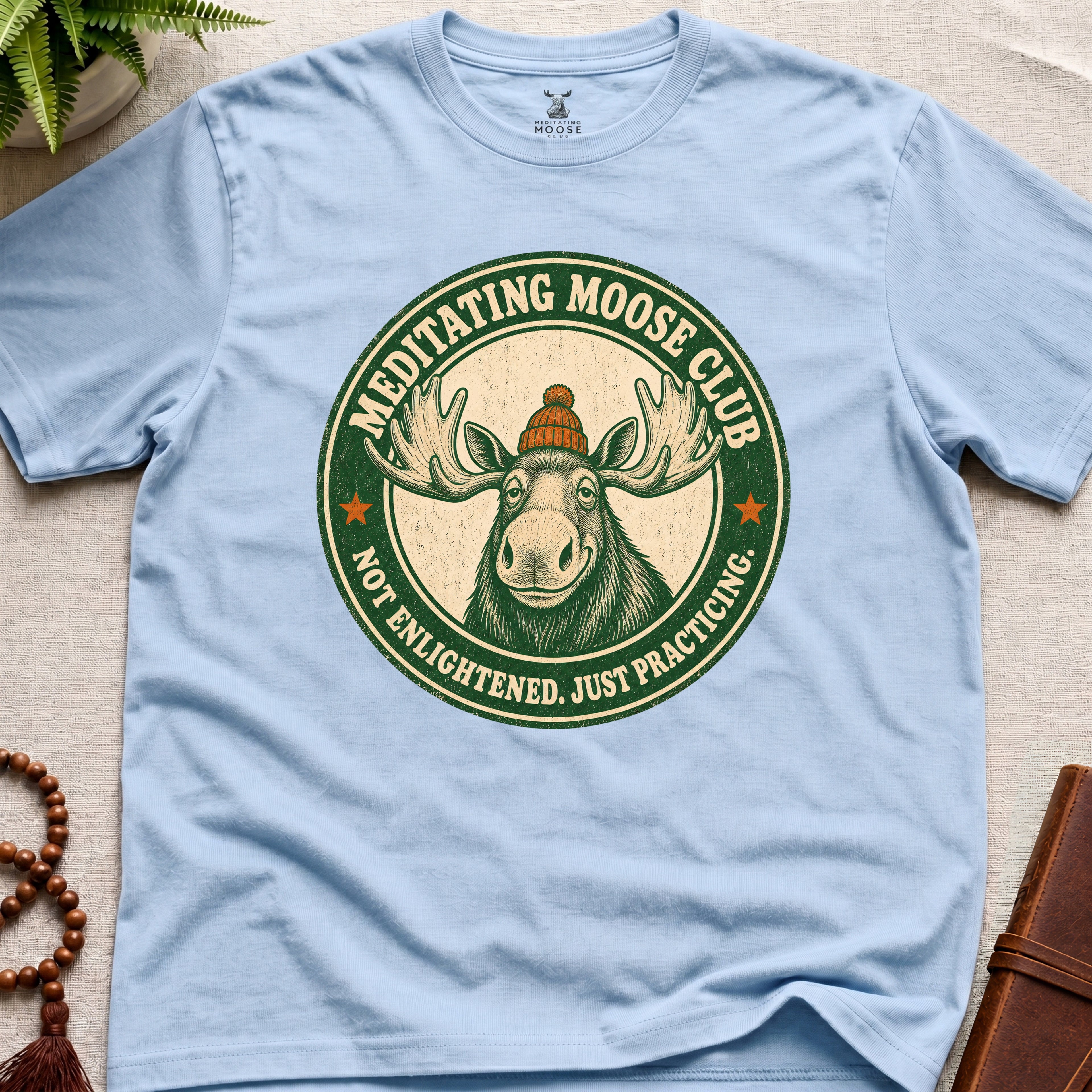 Light blue mindfulness t-shirt mockup featuring Meditating Moose Club signature moose logo graphic