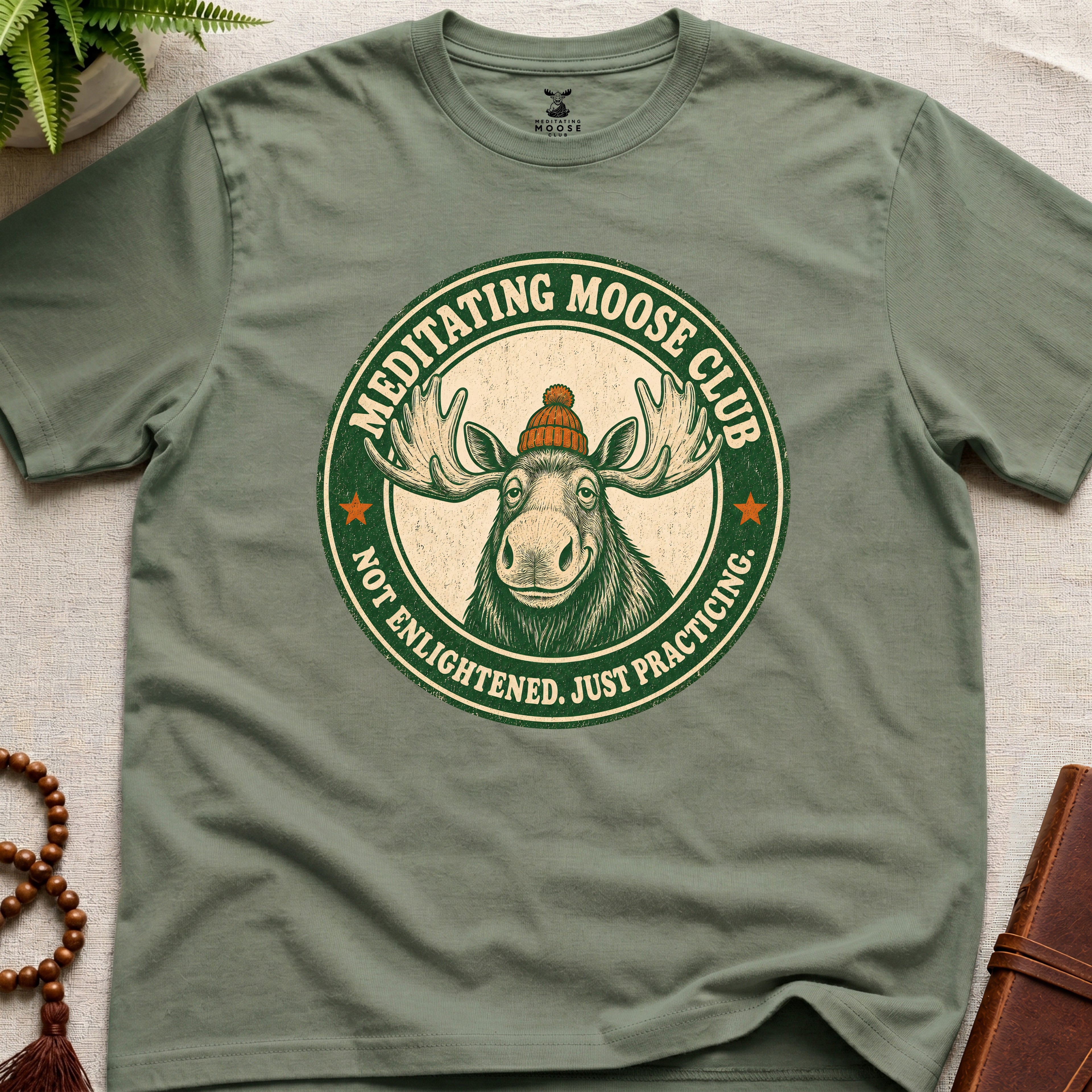 Green mindfulness t-shirt mockup featuring Meditating Moose Club signature moose logo graphic