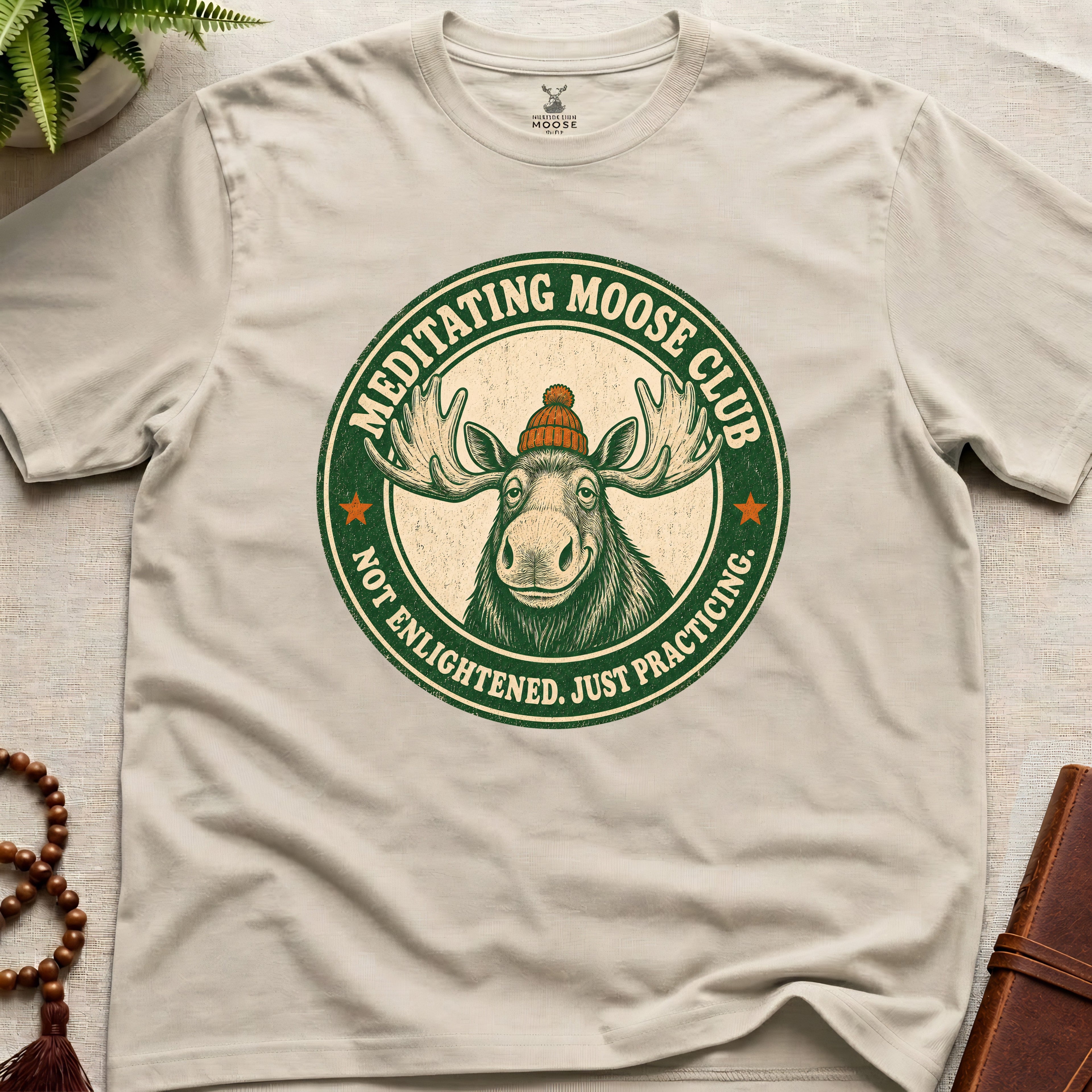 Beige mindfulness t-shirt mockup featuring Meditating Moose Club signature moose logo graphic