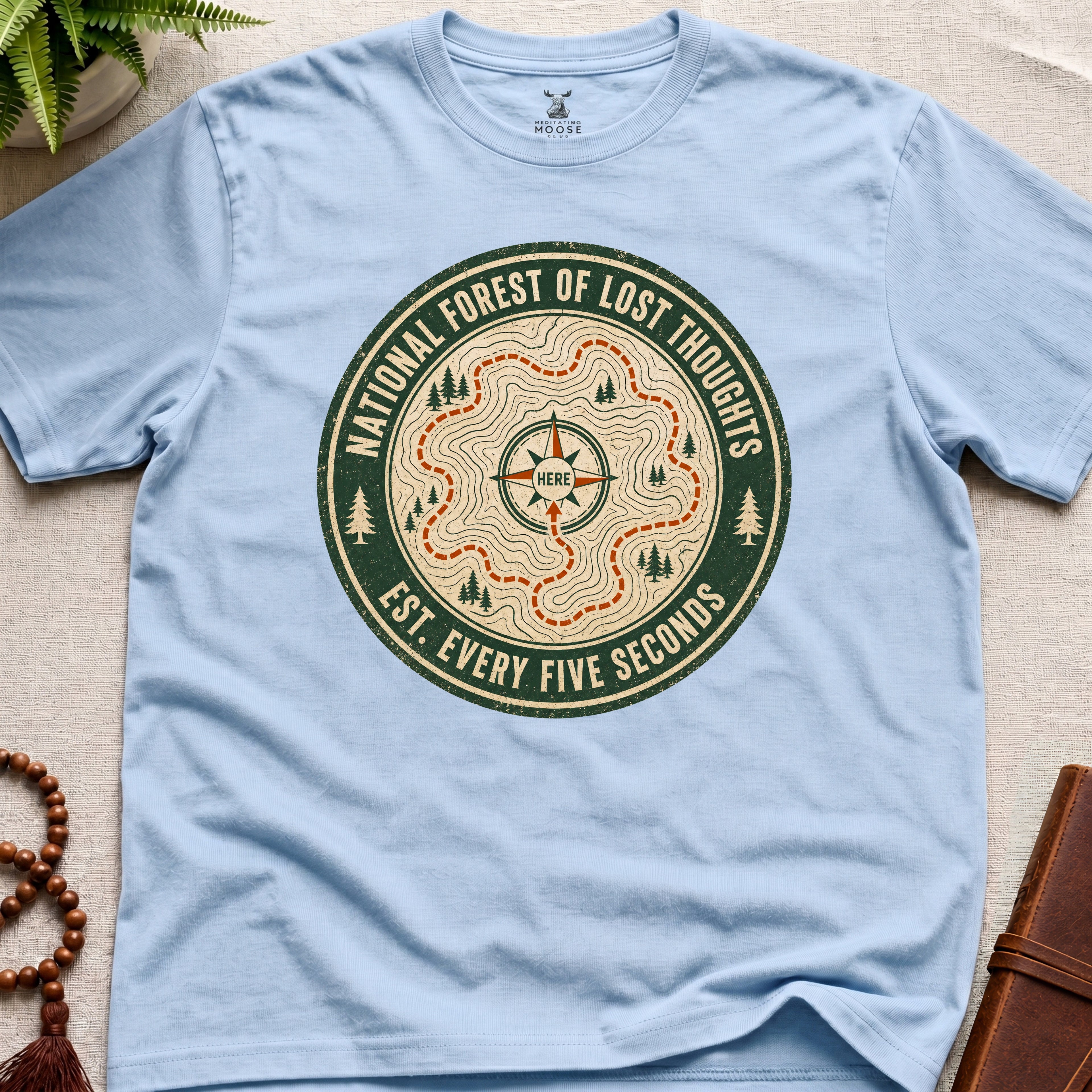 Light blue mindfulness t-shirt mockup featuring National Forest of Lost Thoughts vintage trail map meditation graphic