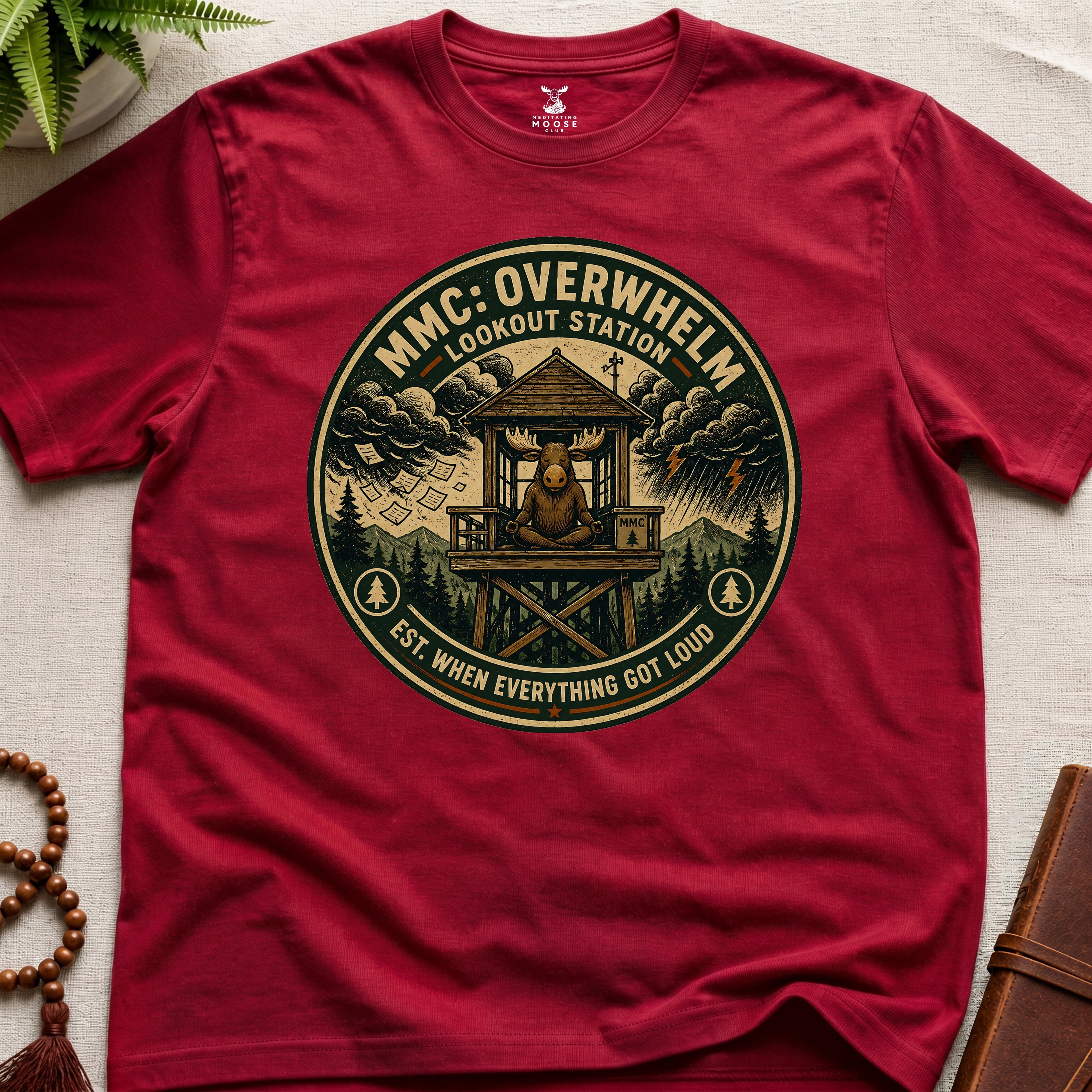 Red mindfulness t-shirt mockup featuring Overwhelm Lookout Station meditating moose stress graphic