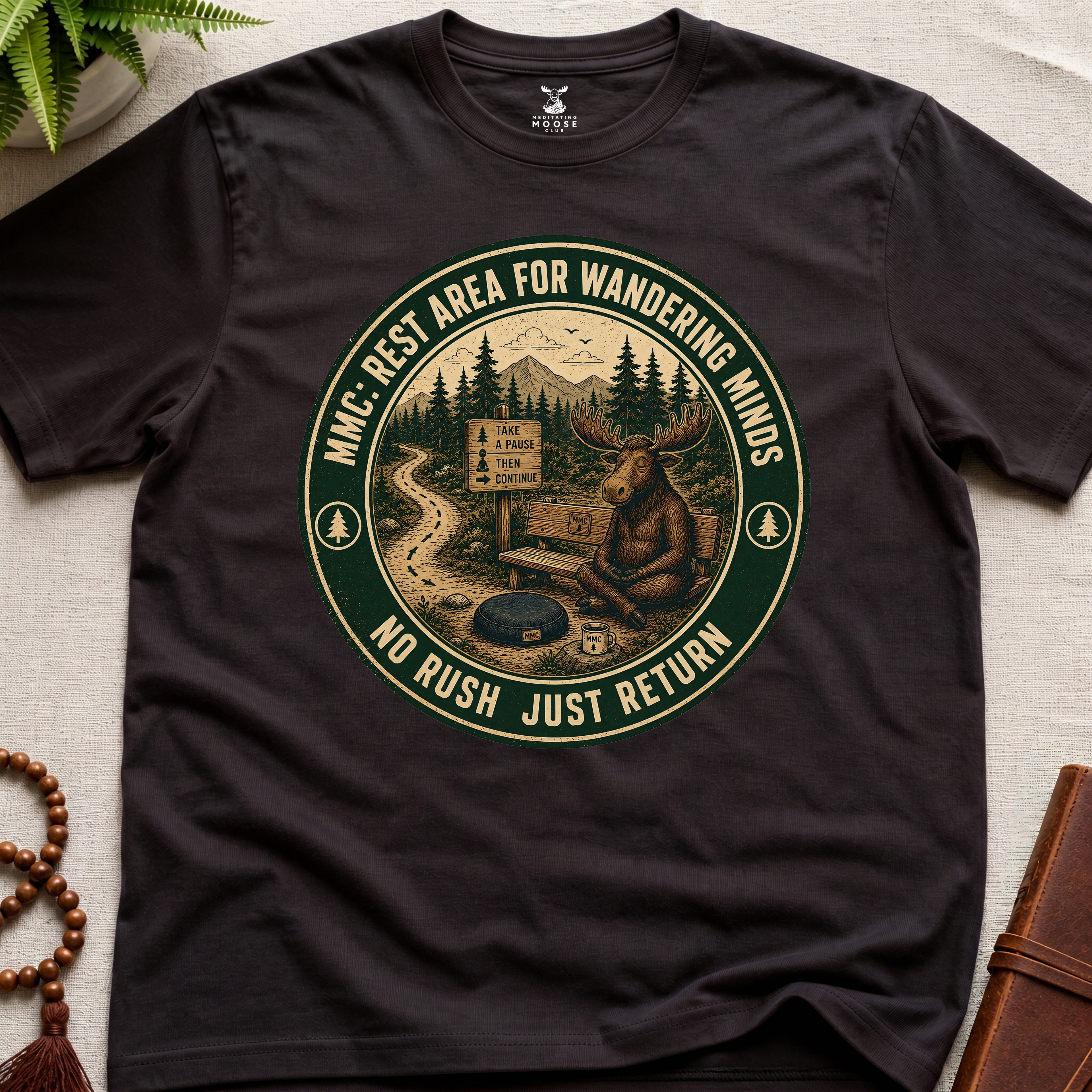Dark brown funny mindfulness t-shirt mockup featuring Rest Area for Wandering Minds meditating moose vintage badge design