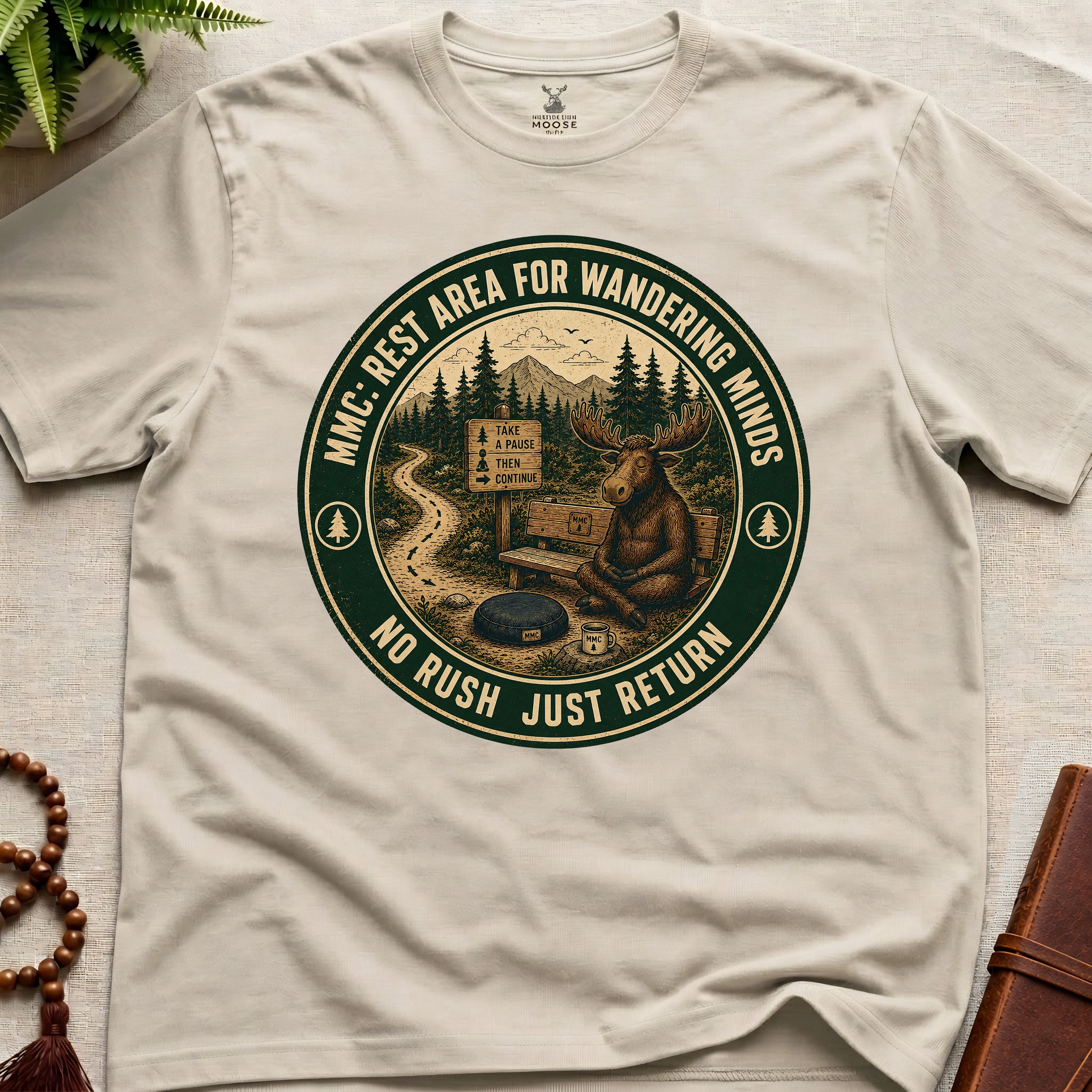 Beige funny mindfulness t-shirt mockup featuring Rest Area for Wandering Minds meditating moose vintage badge design
