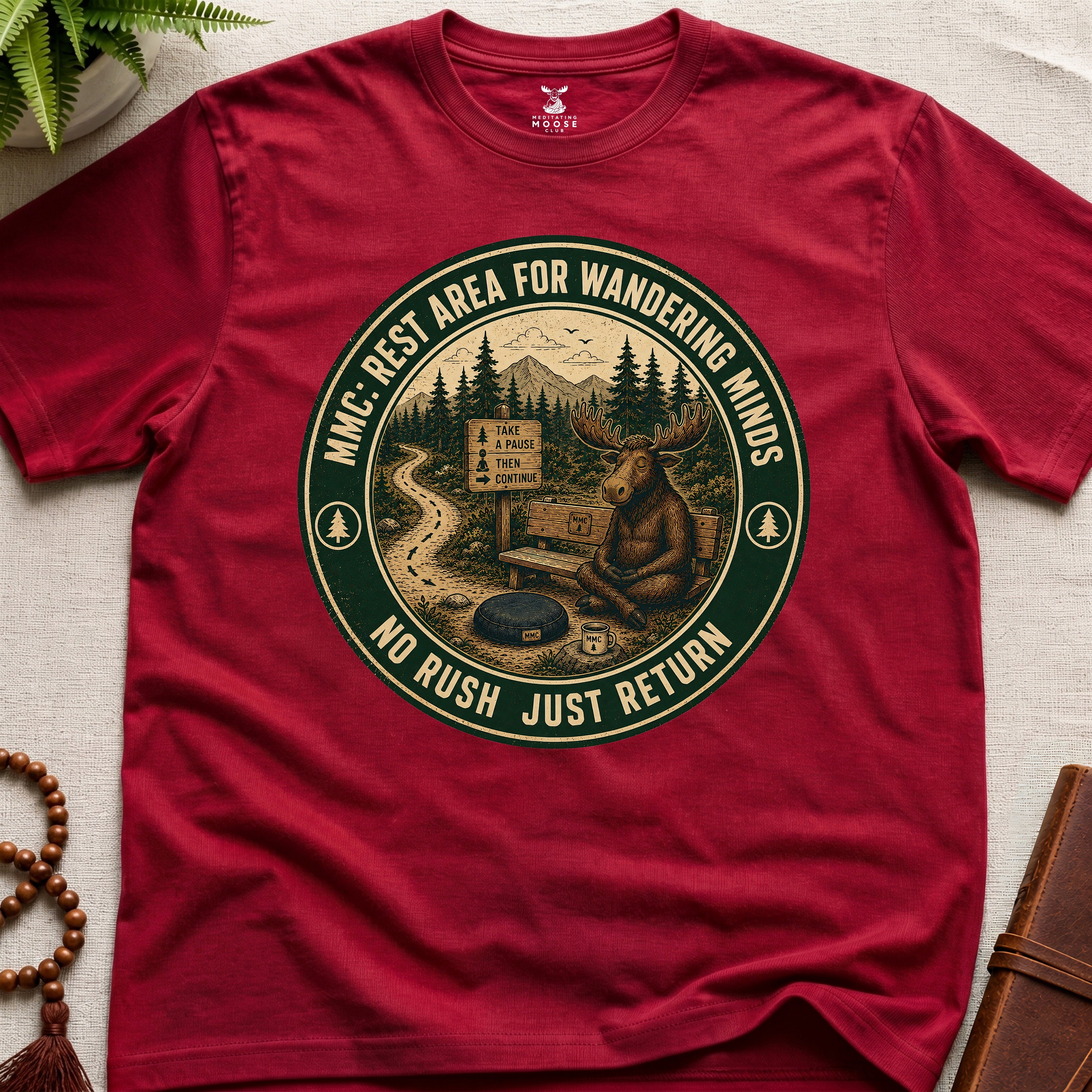 Red funny mindfulness t-shirt mockup featuring Rest Area for Wandering Minds meditating moose vintage badge design