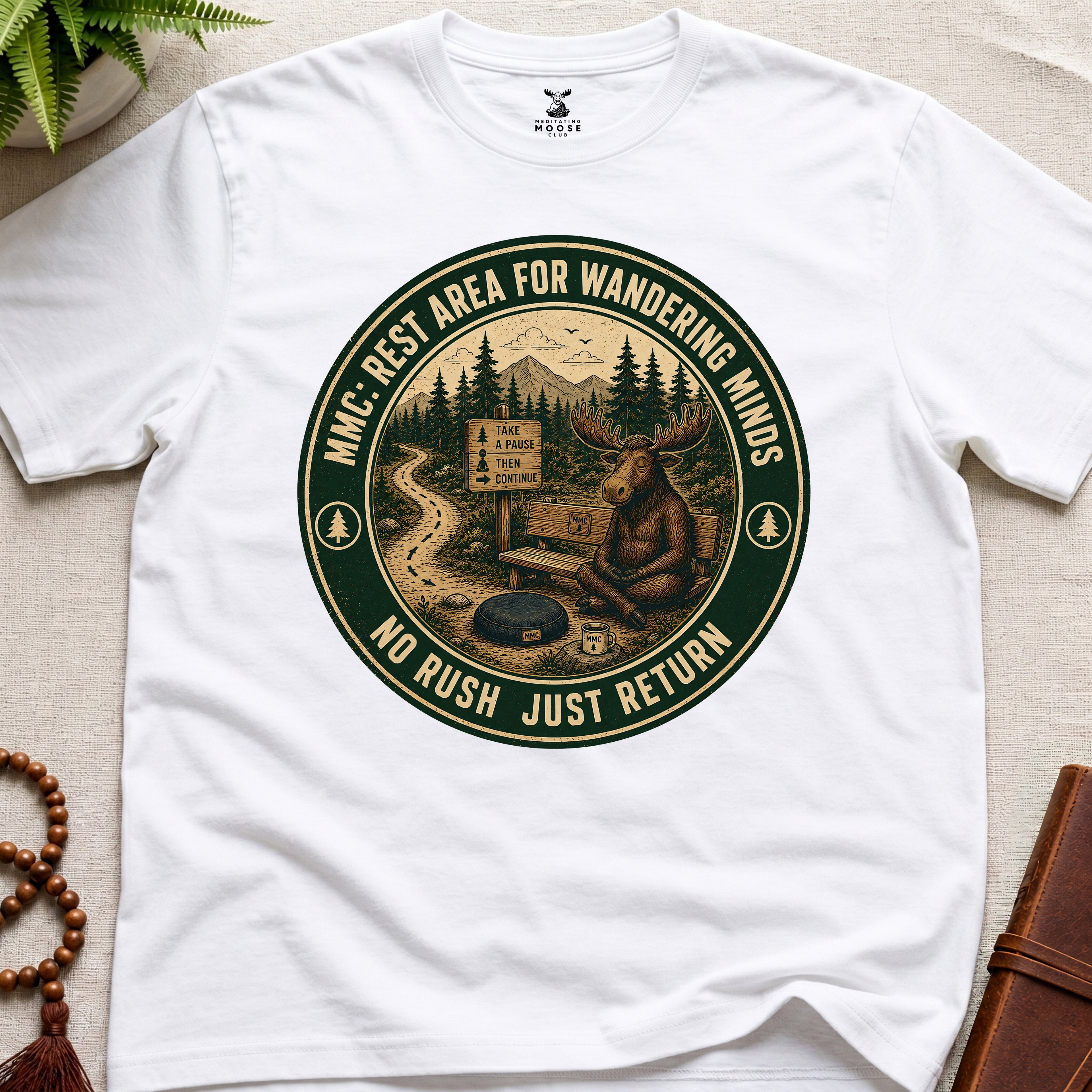 White funny mindfulness t-shirt mockup featuring Rest Area for Wandering Minds meditating moose vintage badge design