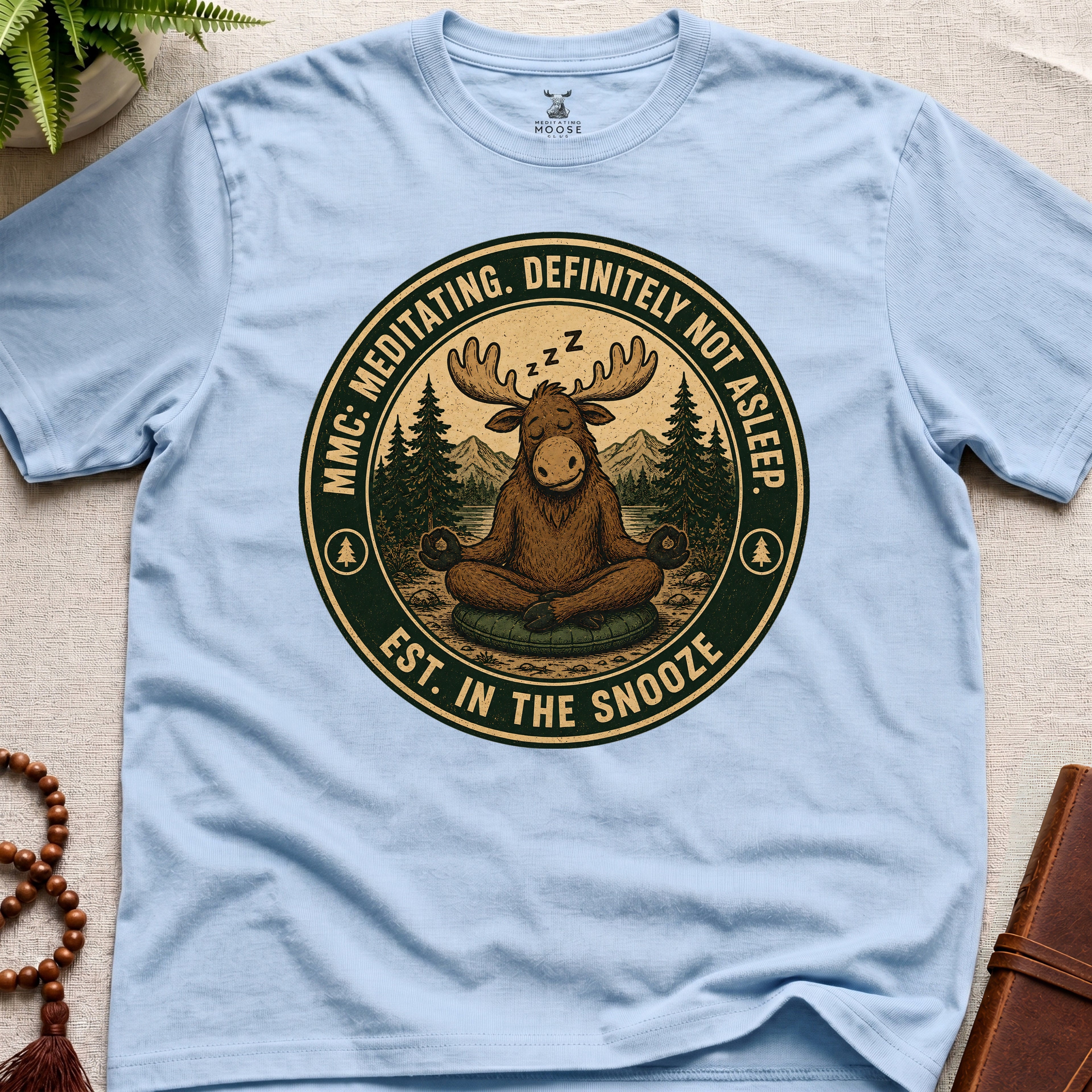 Light blue funny meditation t-shirt mockup featuring Meditating Moose Club sleepy moose mindfulness graphic