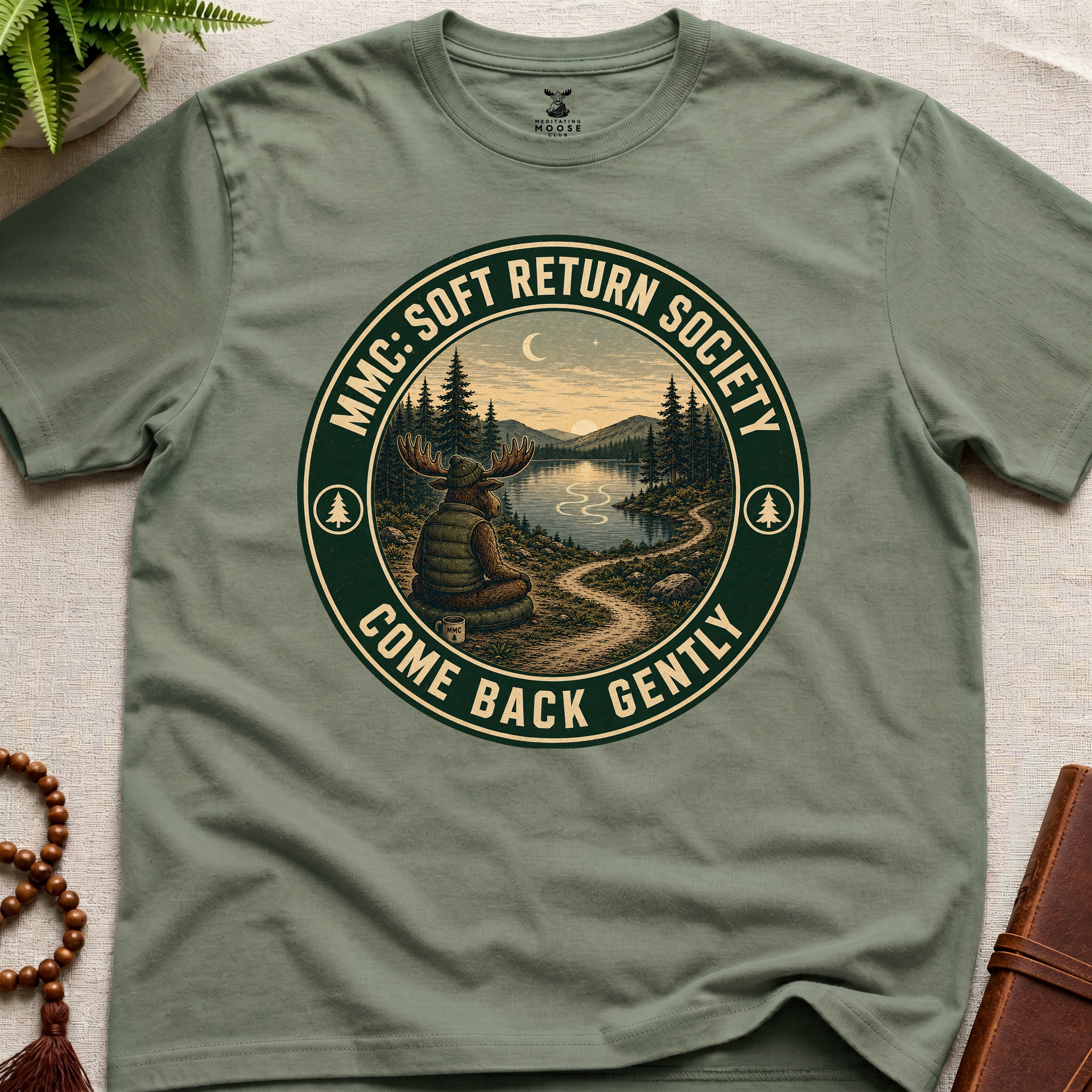 Green mindfulness t-shirt mockup featuring Soft Return Society vintage wilderness meditation badge design