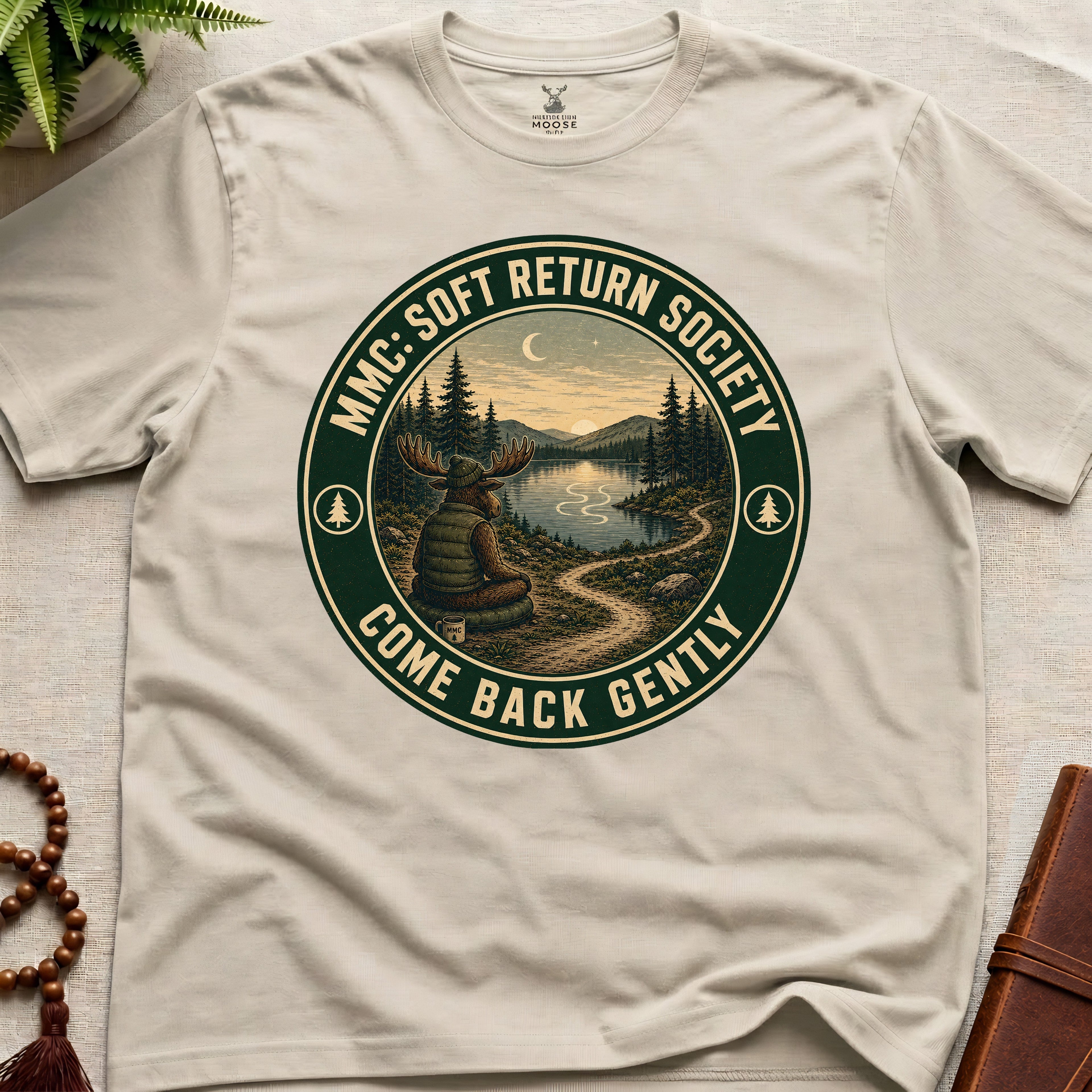 Beige mindfulness t-shirt mockup featuring Soft Return Society vintage wilderness meditation badge design