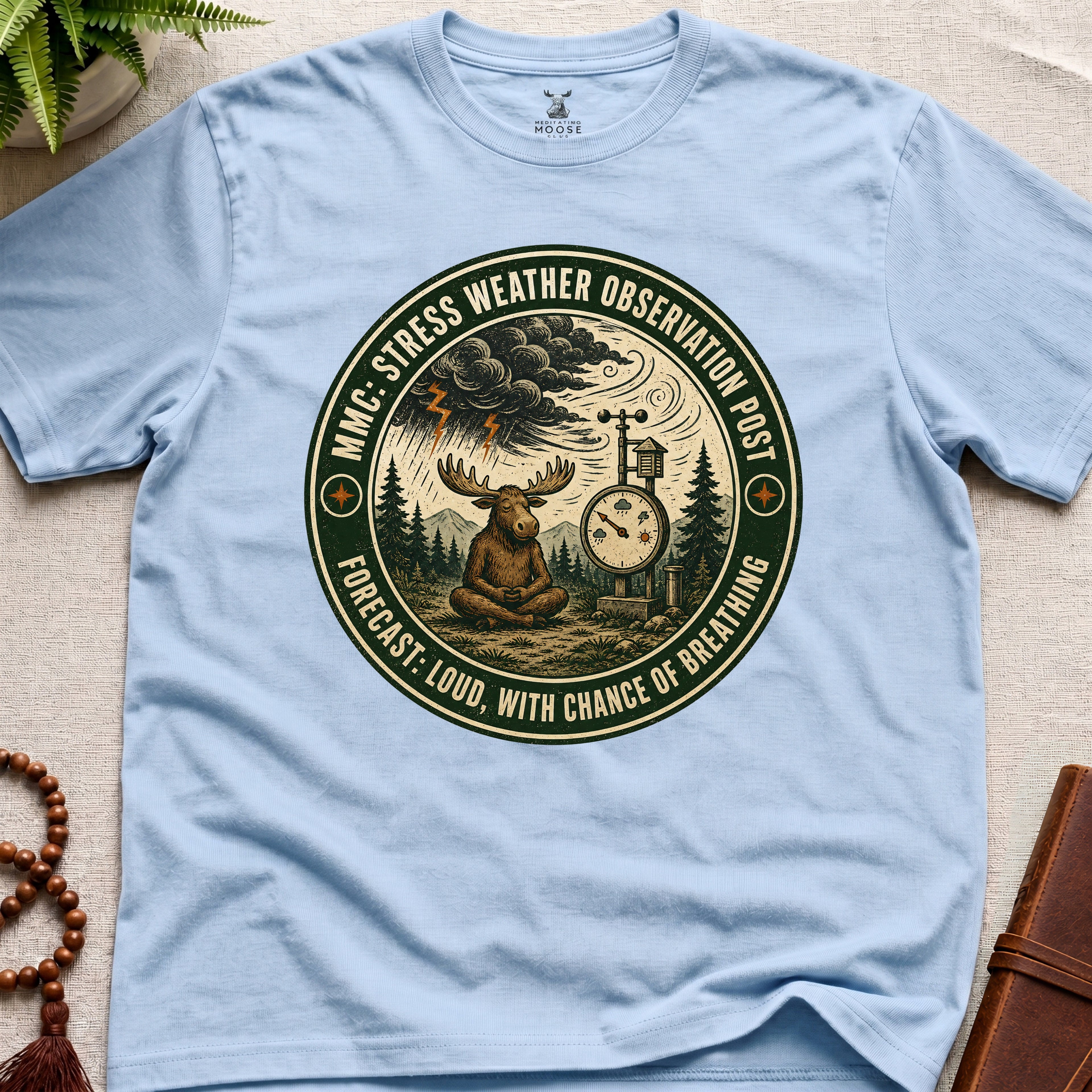 Light blue funny mindfulness t-shirt mockup featuring Stress Weather Observation Post meditating moose graphic