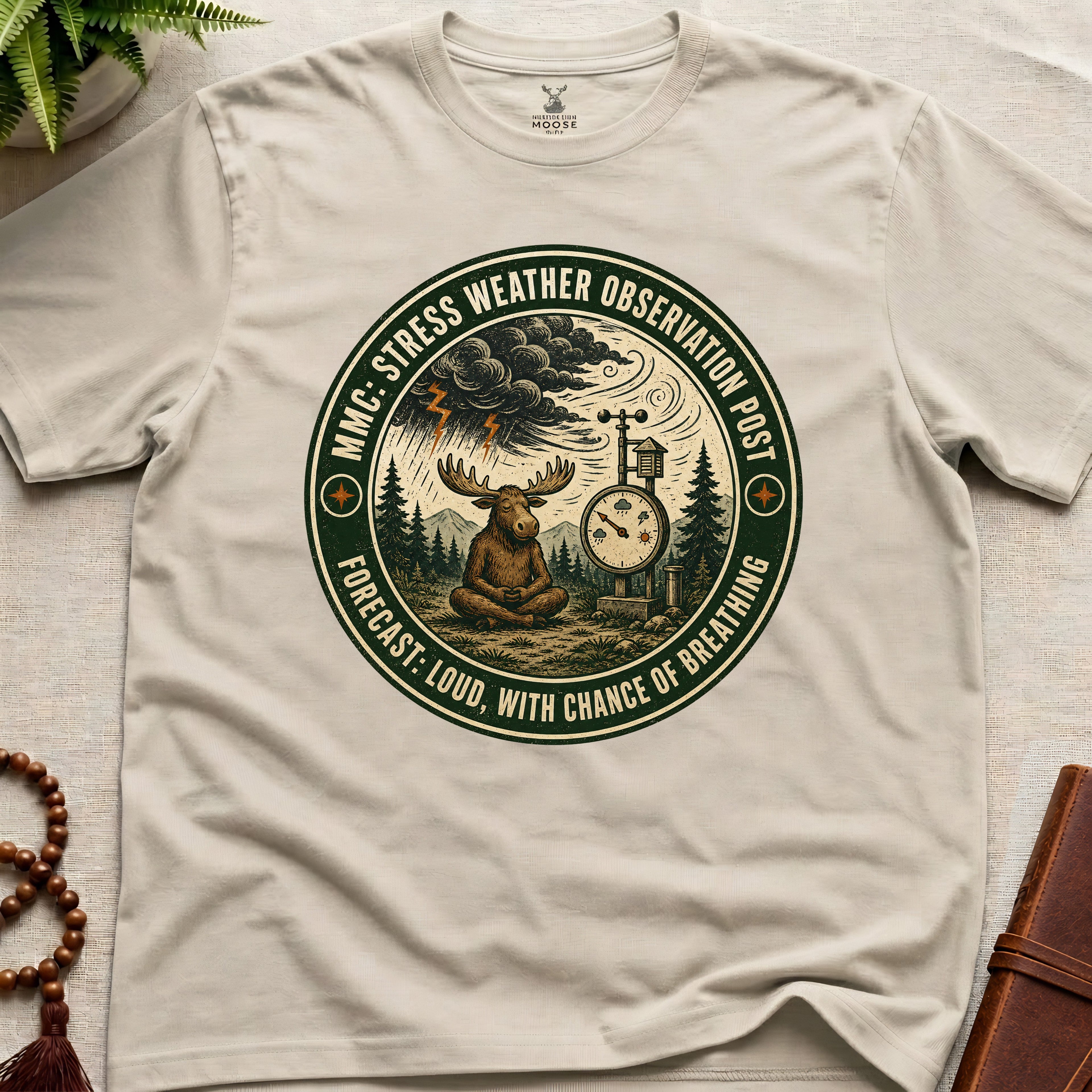 Beige funny mindfulness t-shirt mockup featuring Stress Weather Observation Post meditating moose graphic