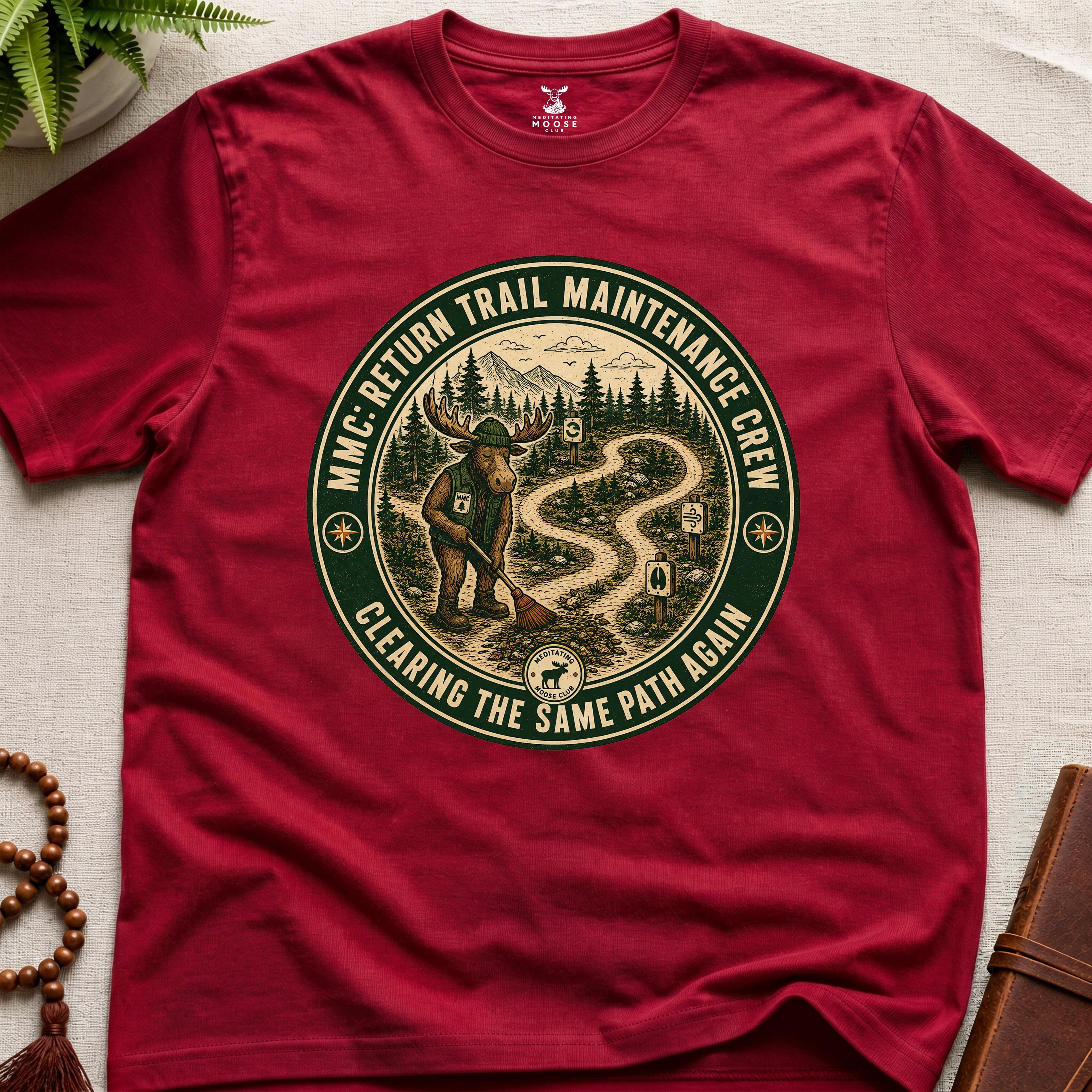 Red mindfulness t-shirt mockup featuring Return Trail Maintenance Crew meditating moose vintage badge graphic