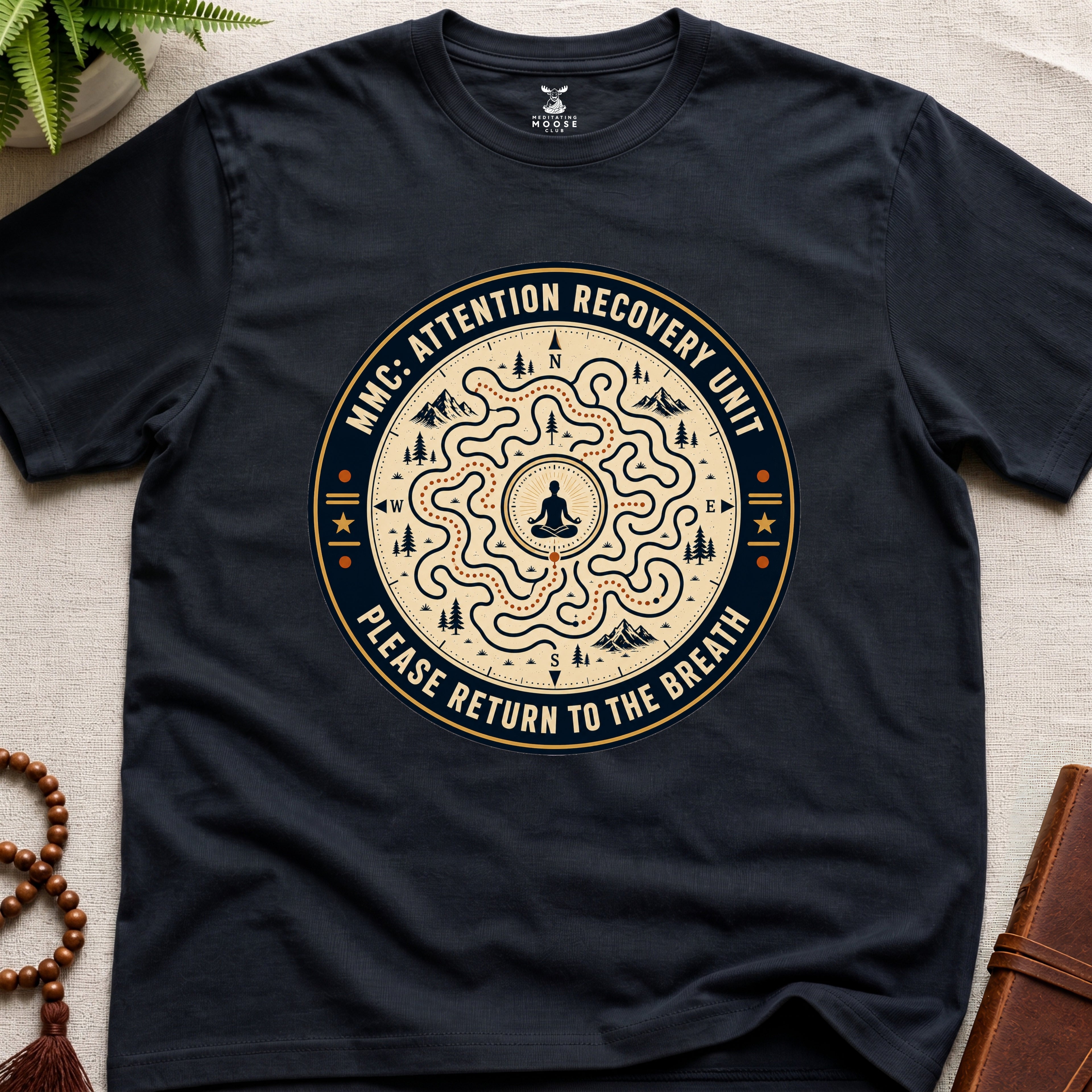 Black unisex mindfulness t-shirt mockup featuring the Meditating Moose Club Attention Recovery Unit graphic with maze navigation design and “Please Return to the Breath” text