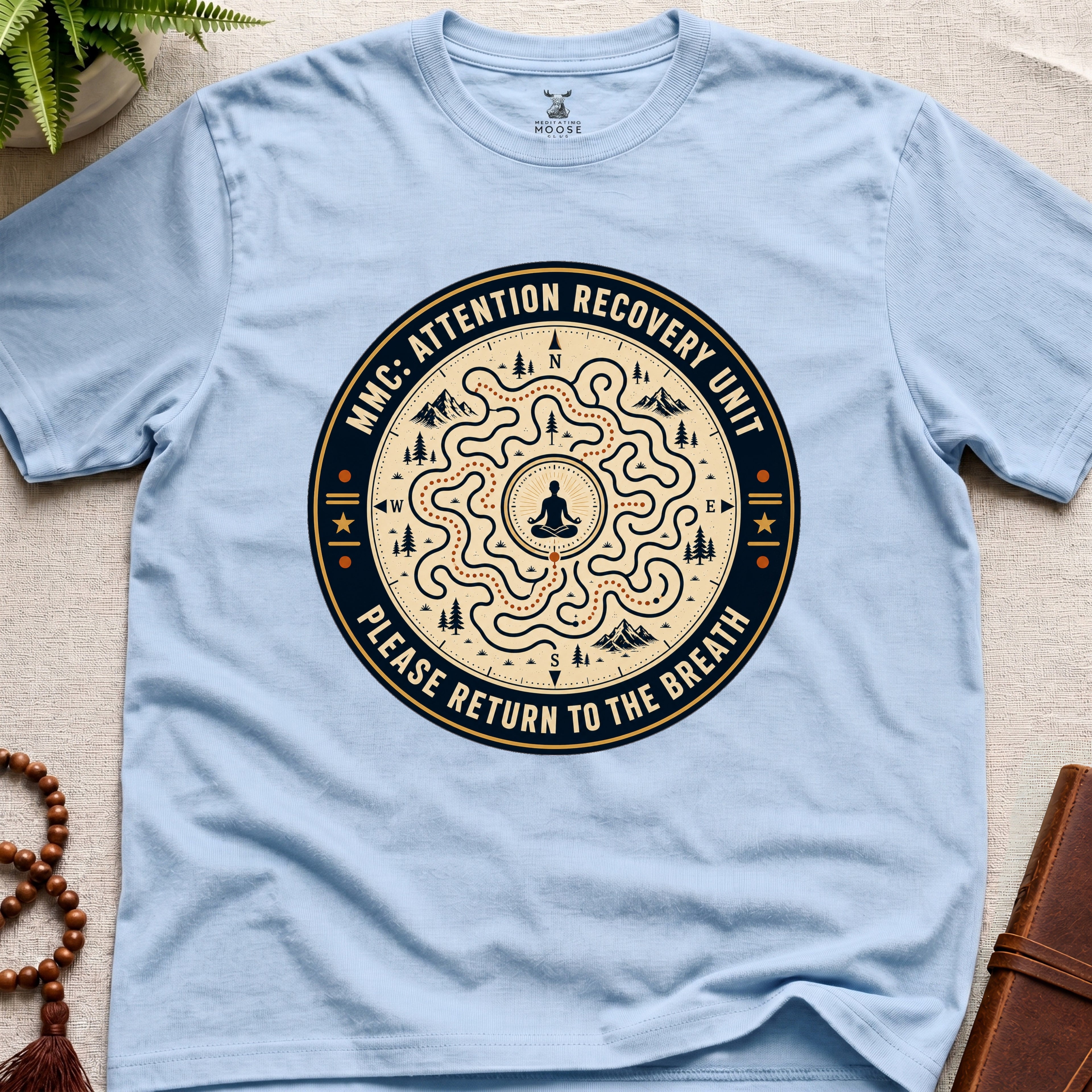 Light blue unisex mindfulness t-shirt mockup featuring the Meditating Moose Club Attention Recovery Unit graphic with maze navigation design and “Please Return to the Breath” text