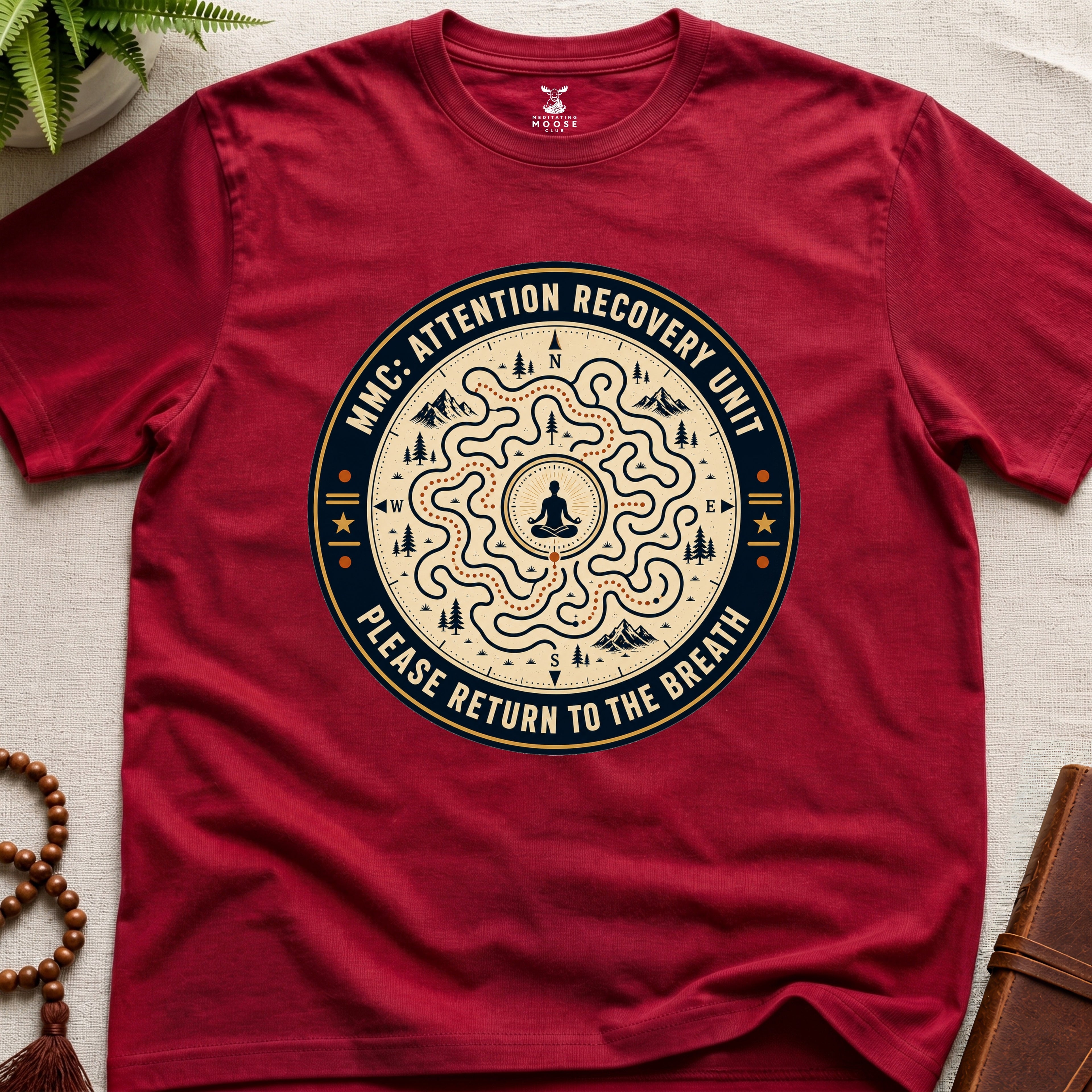 Red unisex mindfulness t-shirt mockup featuring the Meditating Moose Club Attention Recovery Unit graphic with maze navigation design and “Please Return to the Breath” text