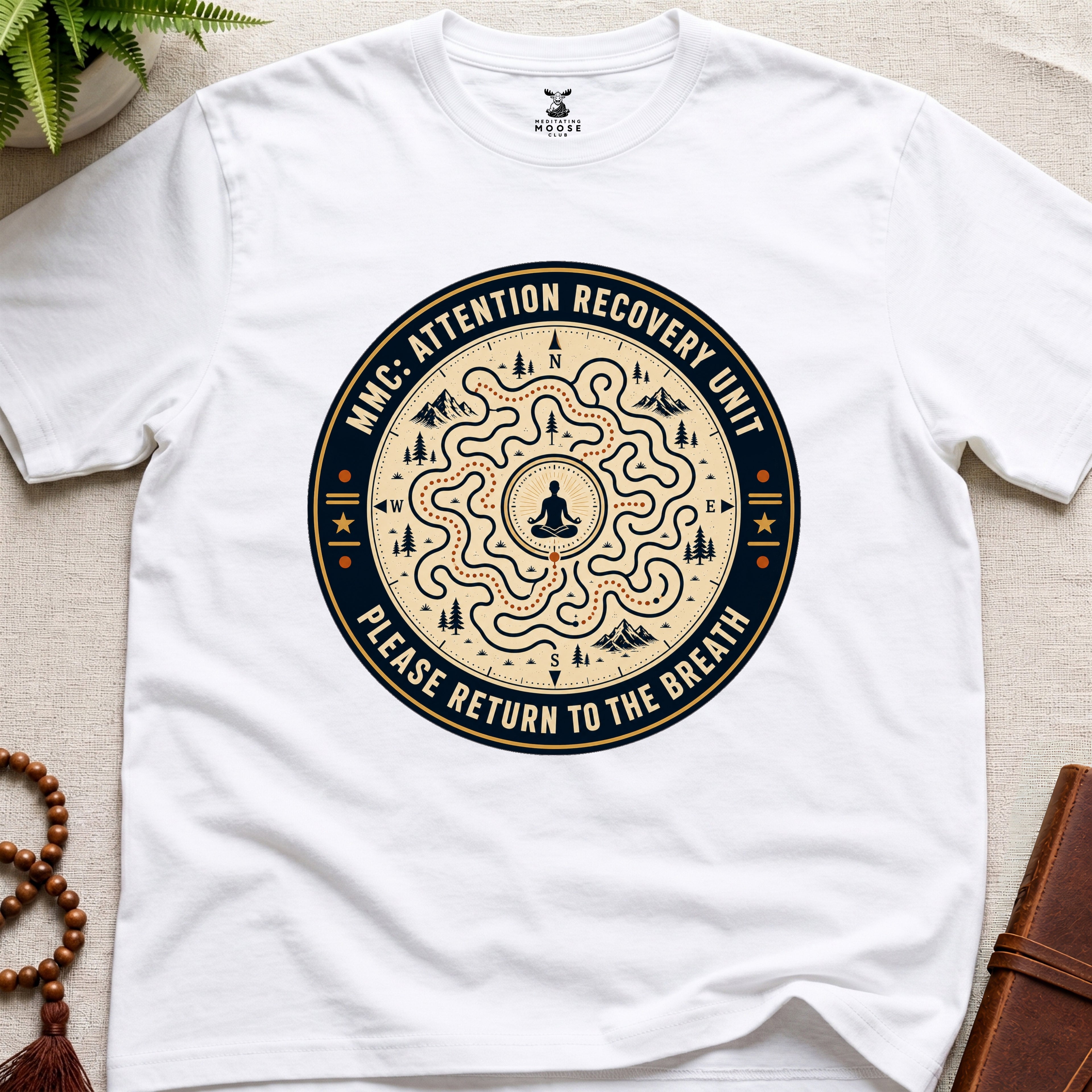 White unisex mindfulness t-shirt mockup featuring the Meditating Moose Club Attention Recovery Unit graphic with maze navigation design and “Please Return to the Breath” text