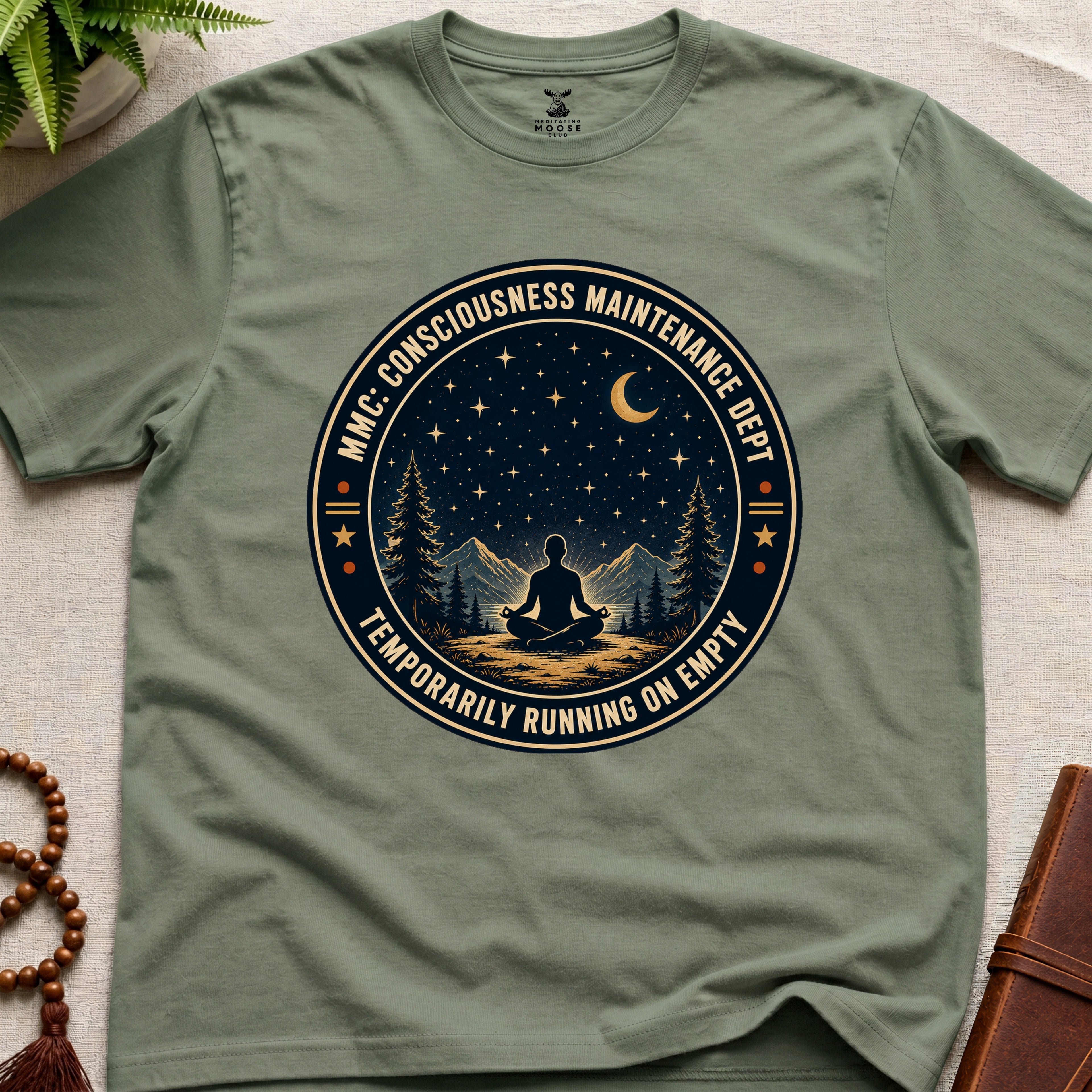 Military green mindfulness t-shirt with a circular badge design featuring a meditating figure and trees - consciousness maintenance dept.