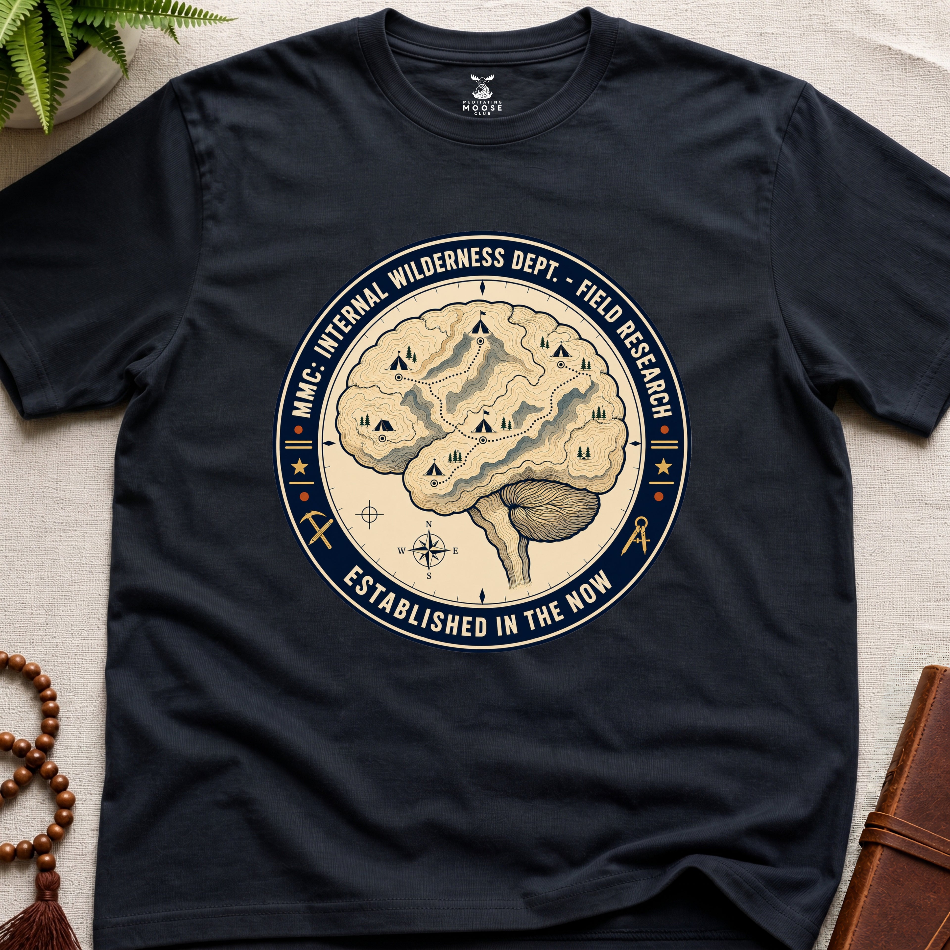 Black mindfulness t-shirt with a brain graphic and text on a light surface.