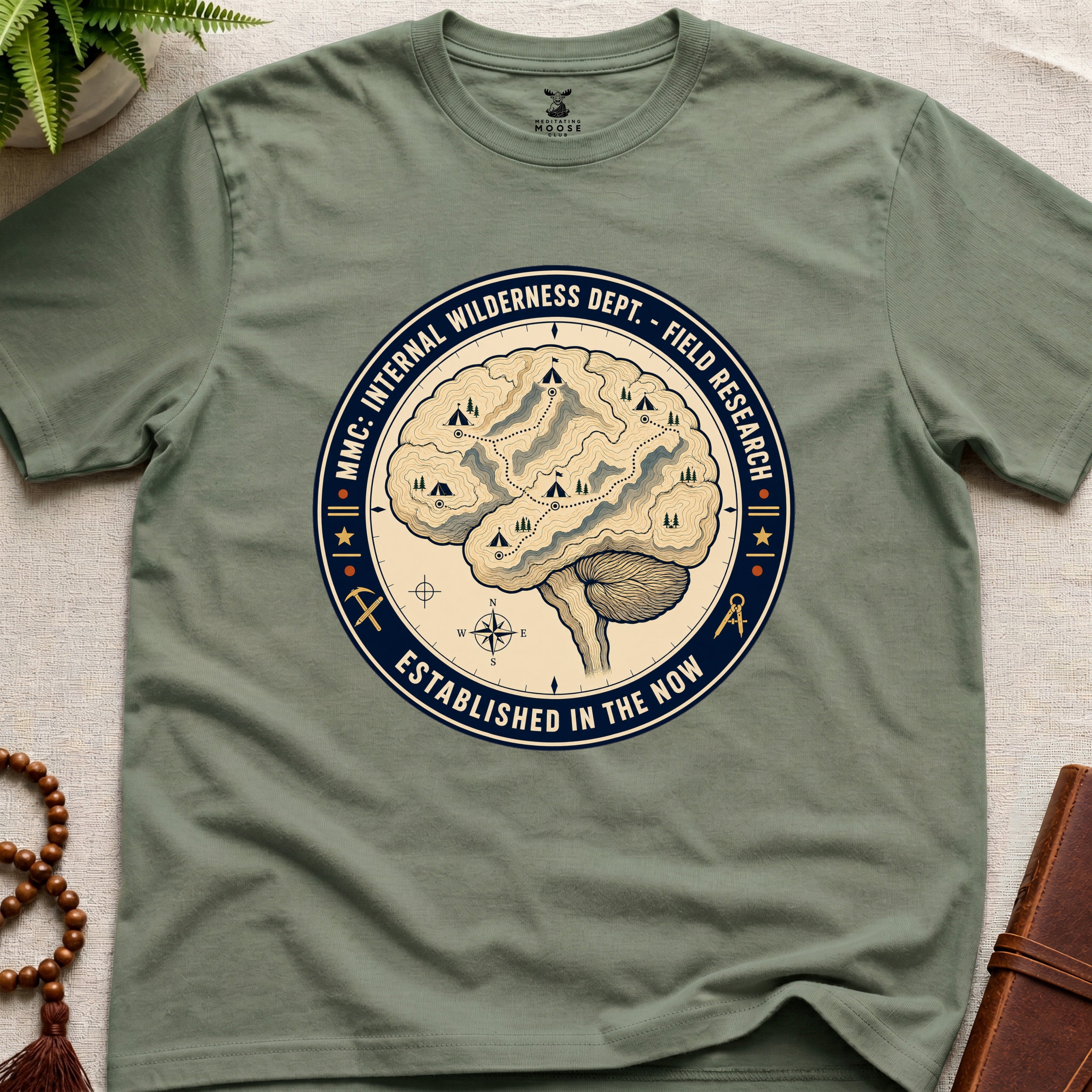 Military green mindfulness t-shirt with a brain graphic and text on a light surface.