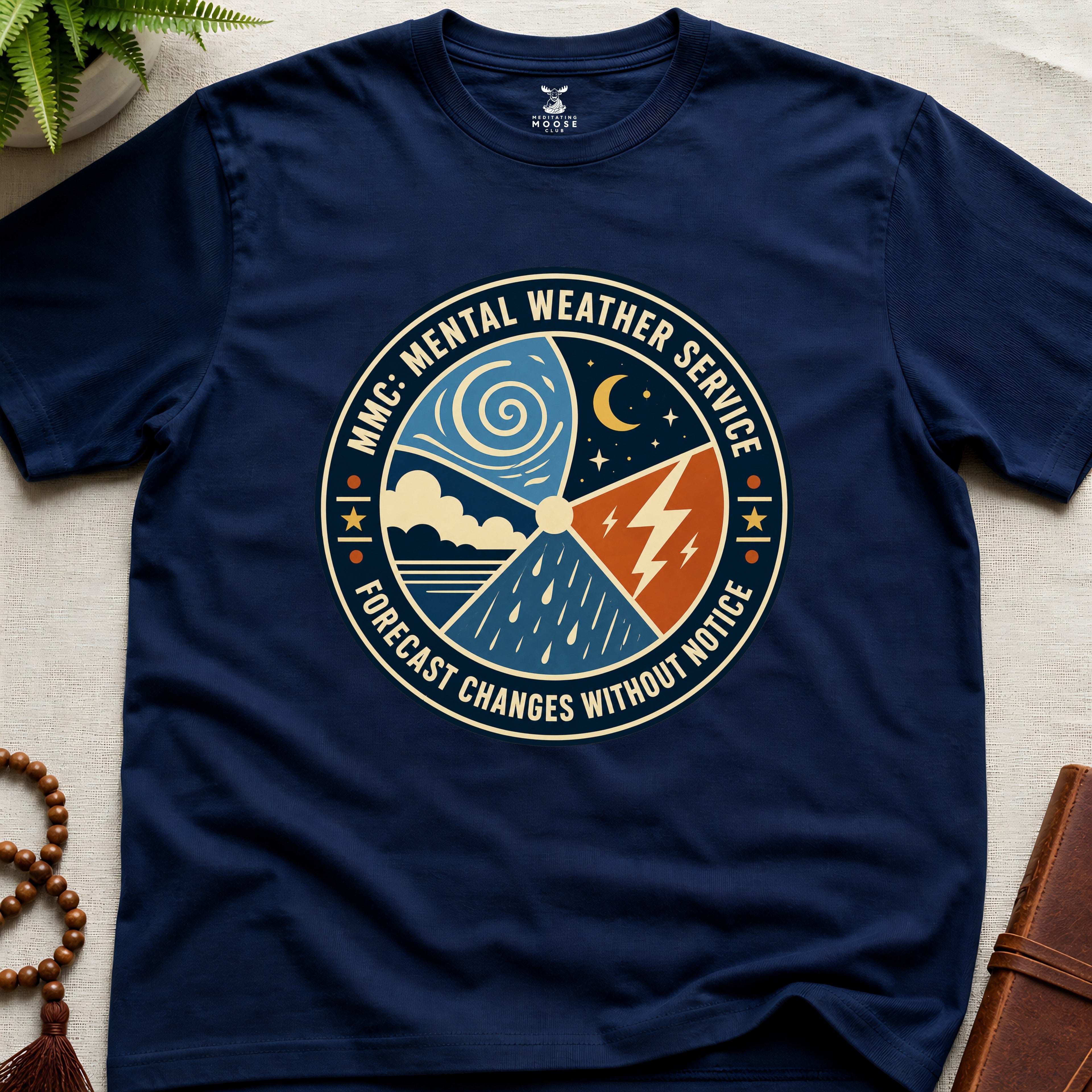 Navy blue t-shirt with a circular graphic design mental weather service on a light surface.