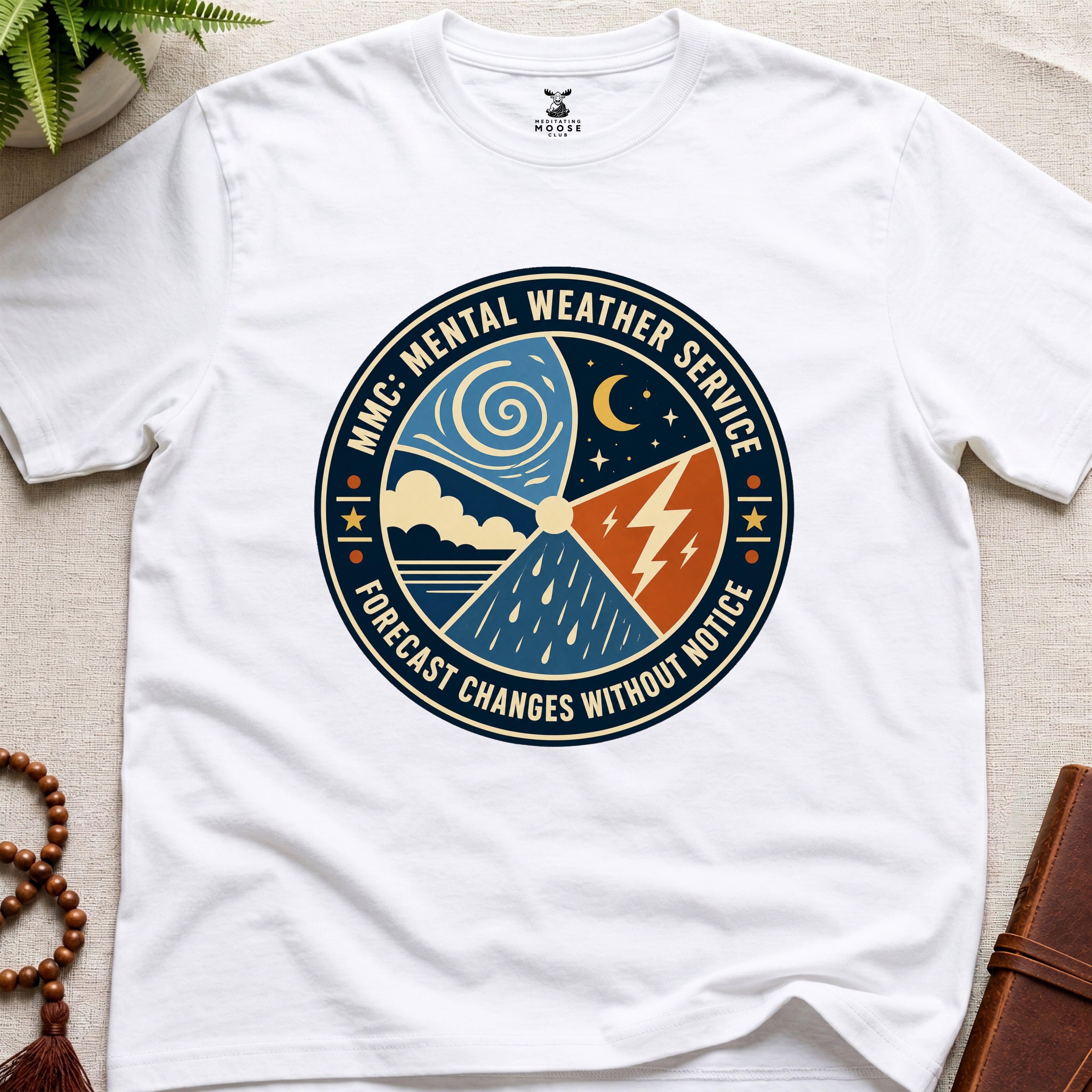 White t-shirt with a circular graphic design mental weather service on a light surface.