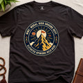 Dark brown t-shirt badge graphic with a mountain and text "moral High Ground Dept." on a light surface.