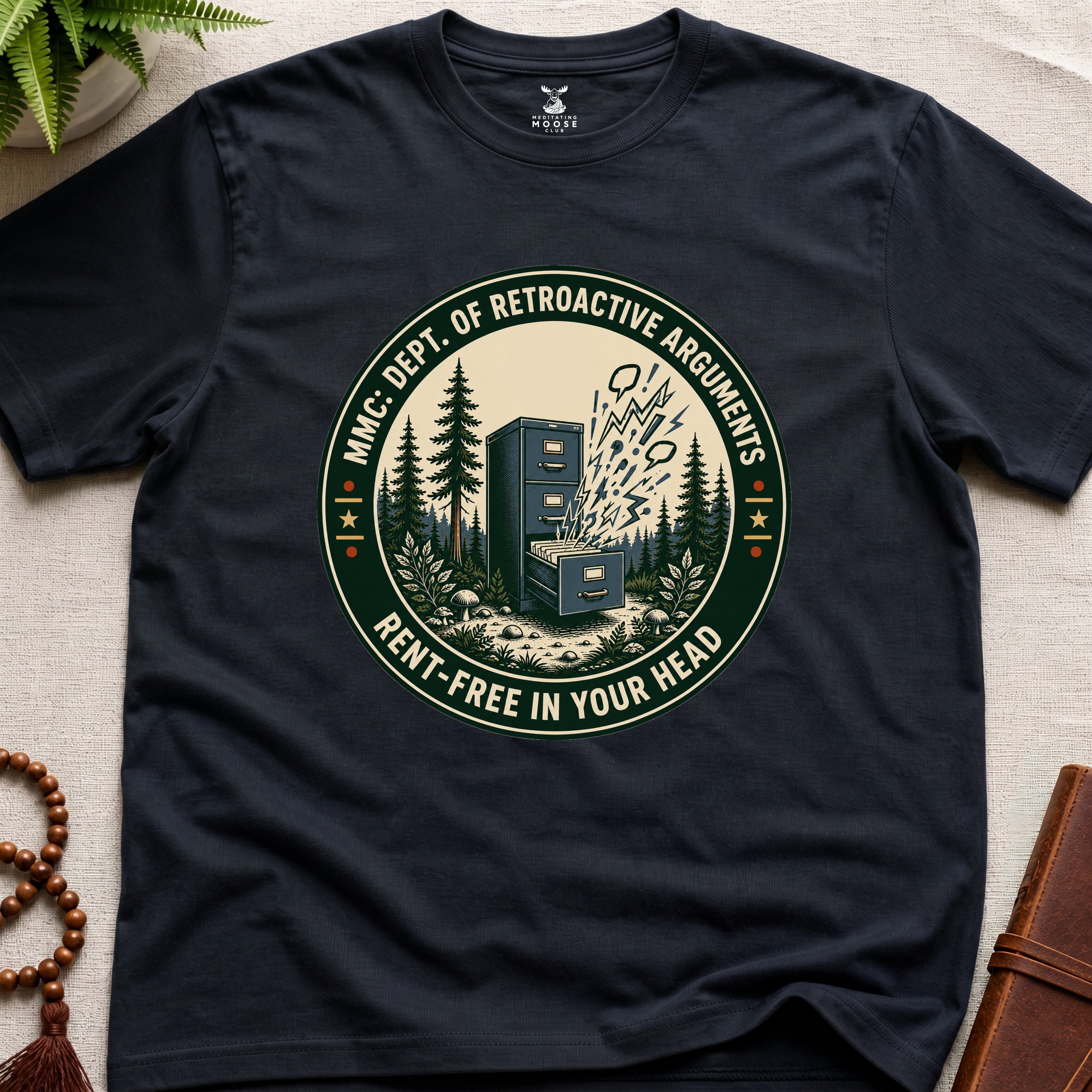Black t-shirt with a badge graphic design "Dept. of retroactive arguments" on a light surface.