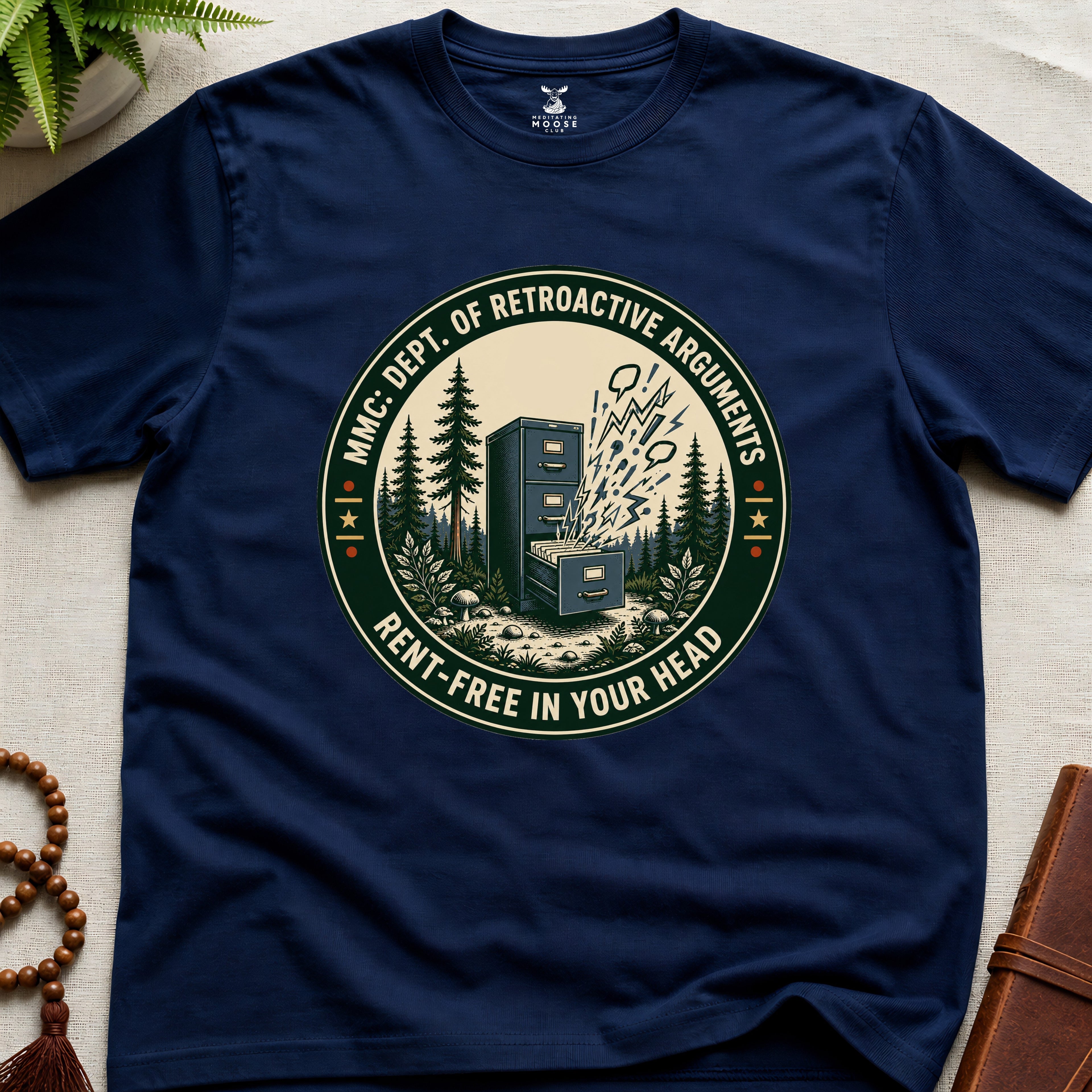 Navy blue t-shirt with a badge graphic design "Dept. of retroactive arguments" on a light surface.