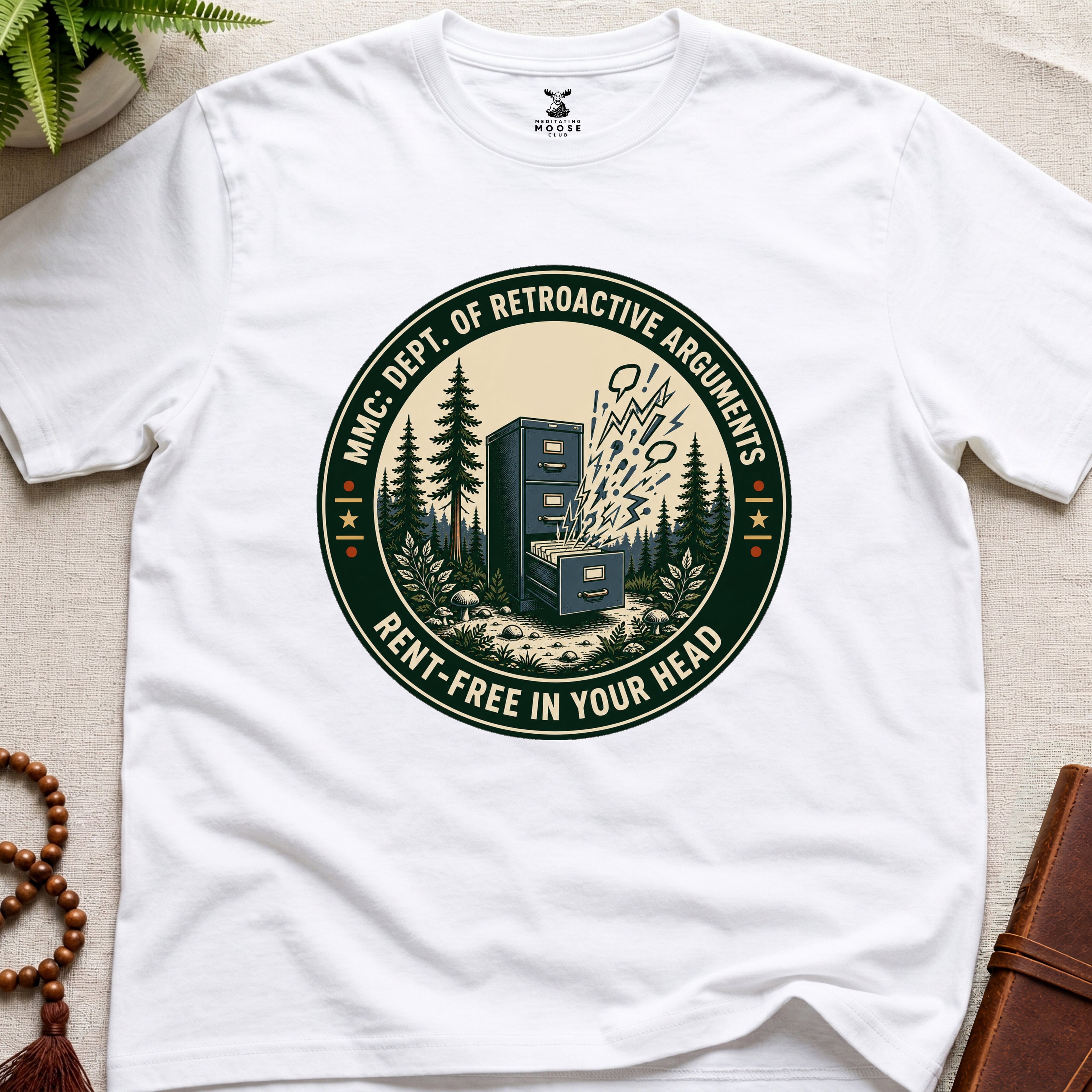 White t-shirt with a badge graphic design "Dept. of retroactive arguments" on a light surface.