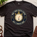 Dark Brown t-shirt with a clock graphic and text "only 2 minutes gone!" on a beige surface.