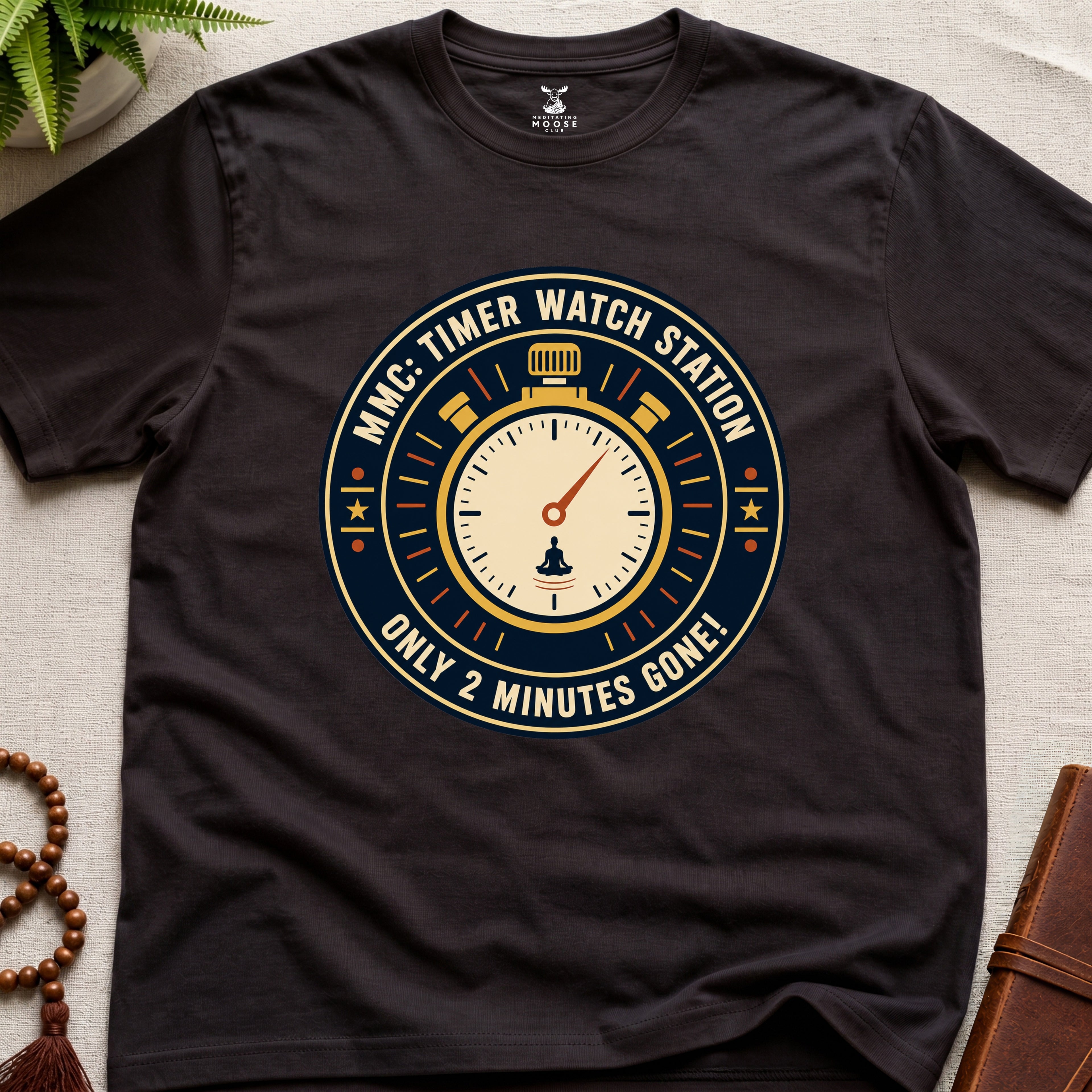 Dark Brown t-shirt with a clock graphic and text "only 2 minutes gone!" on a beige surface.