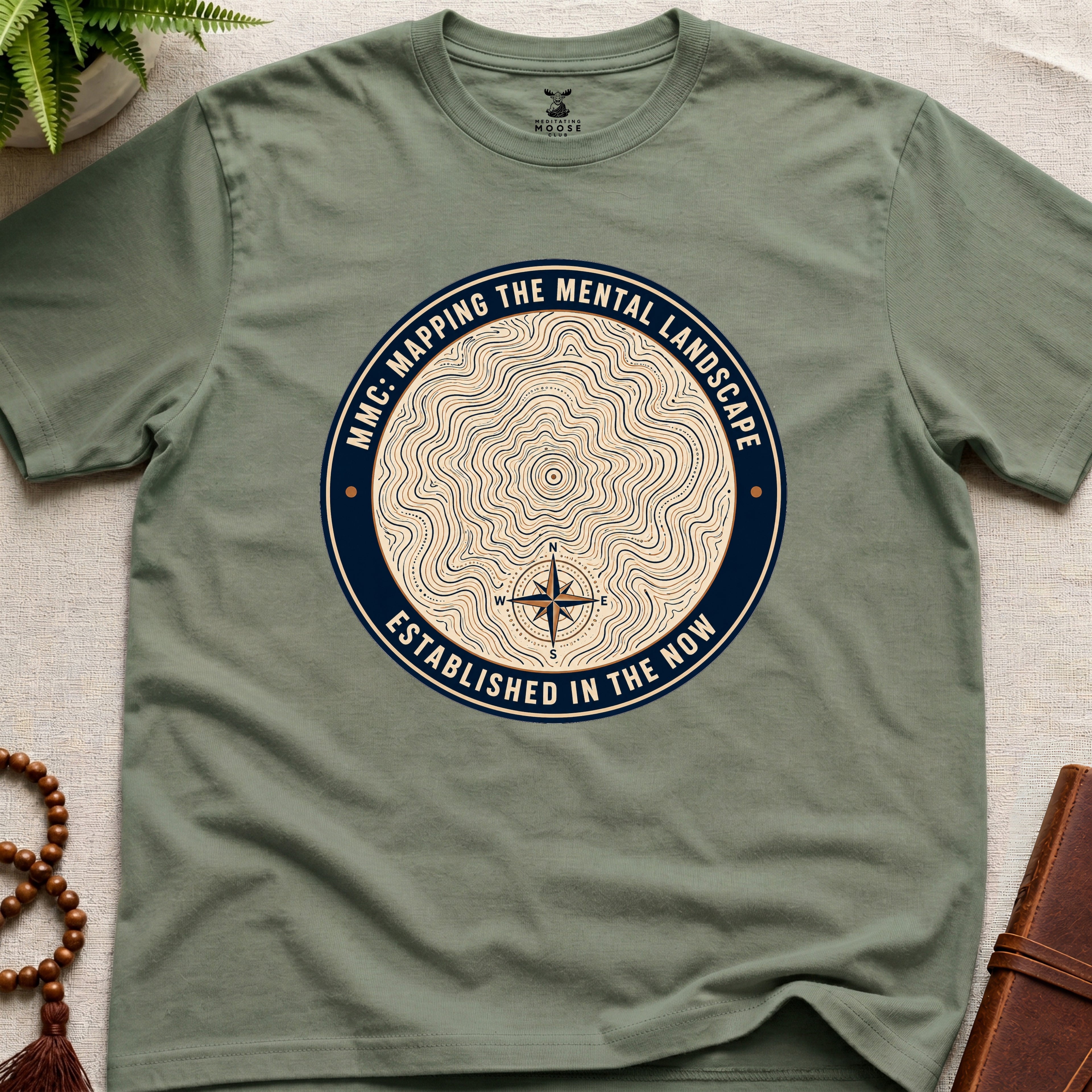 Military green mindfulness t-shirt with topographic landscape badge design featuring compass
