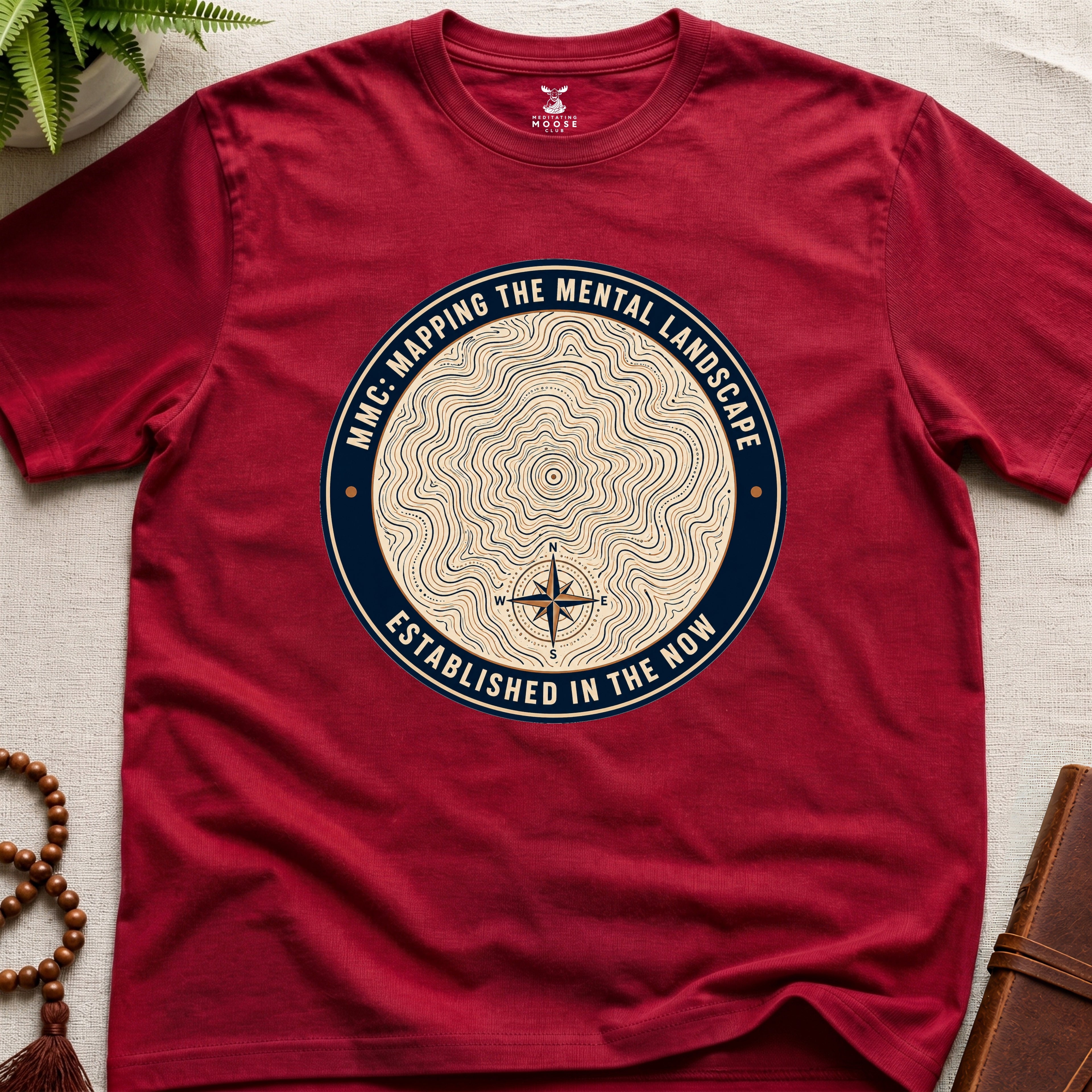 Red mindfulness t-shirt with topographic landscape badge design featuring compass