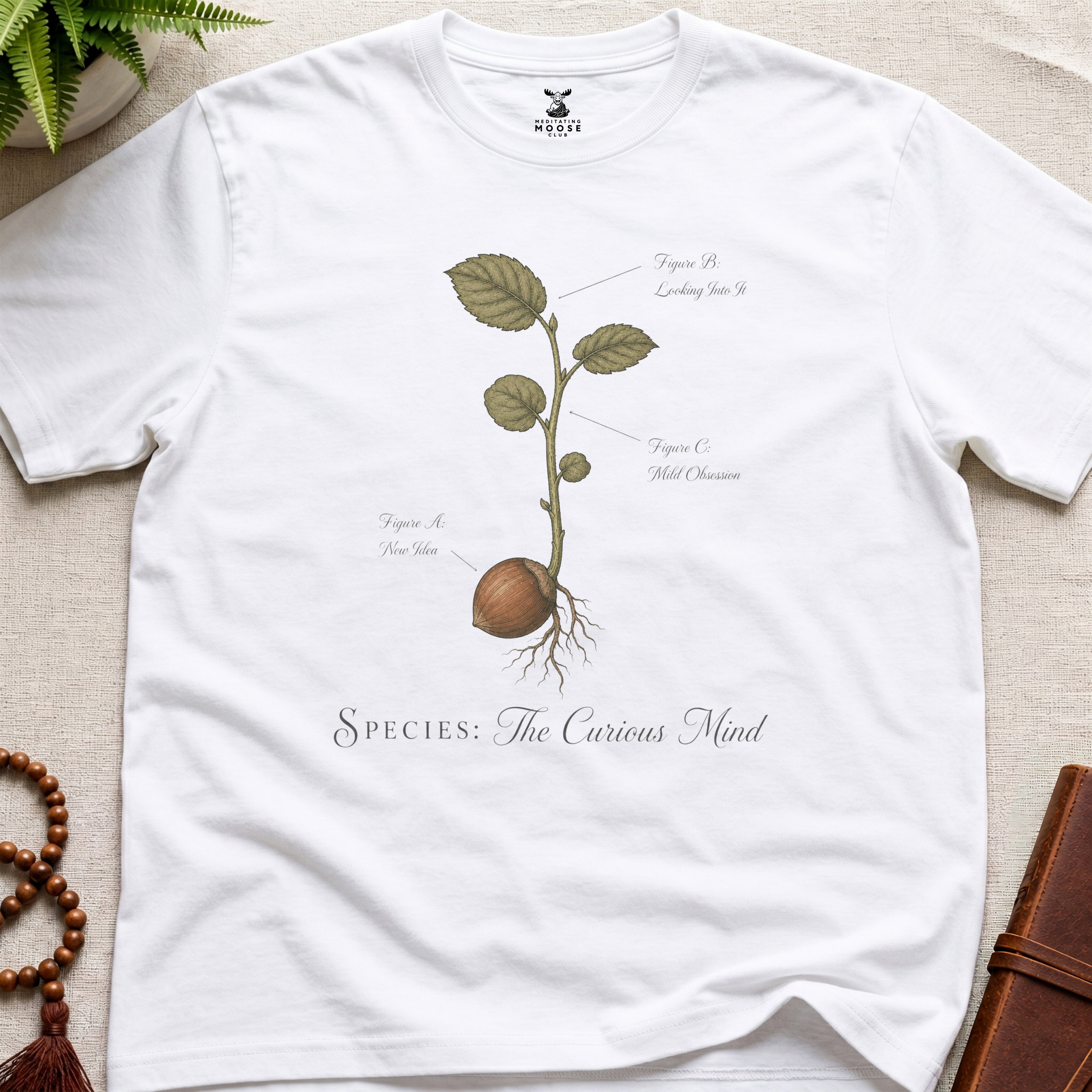 White vintage botanical graphic t-shirt featuring wandering mind natural history illustration