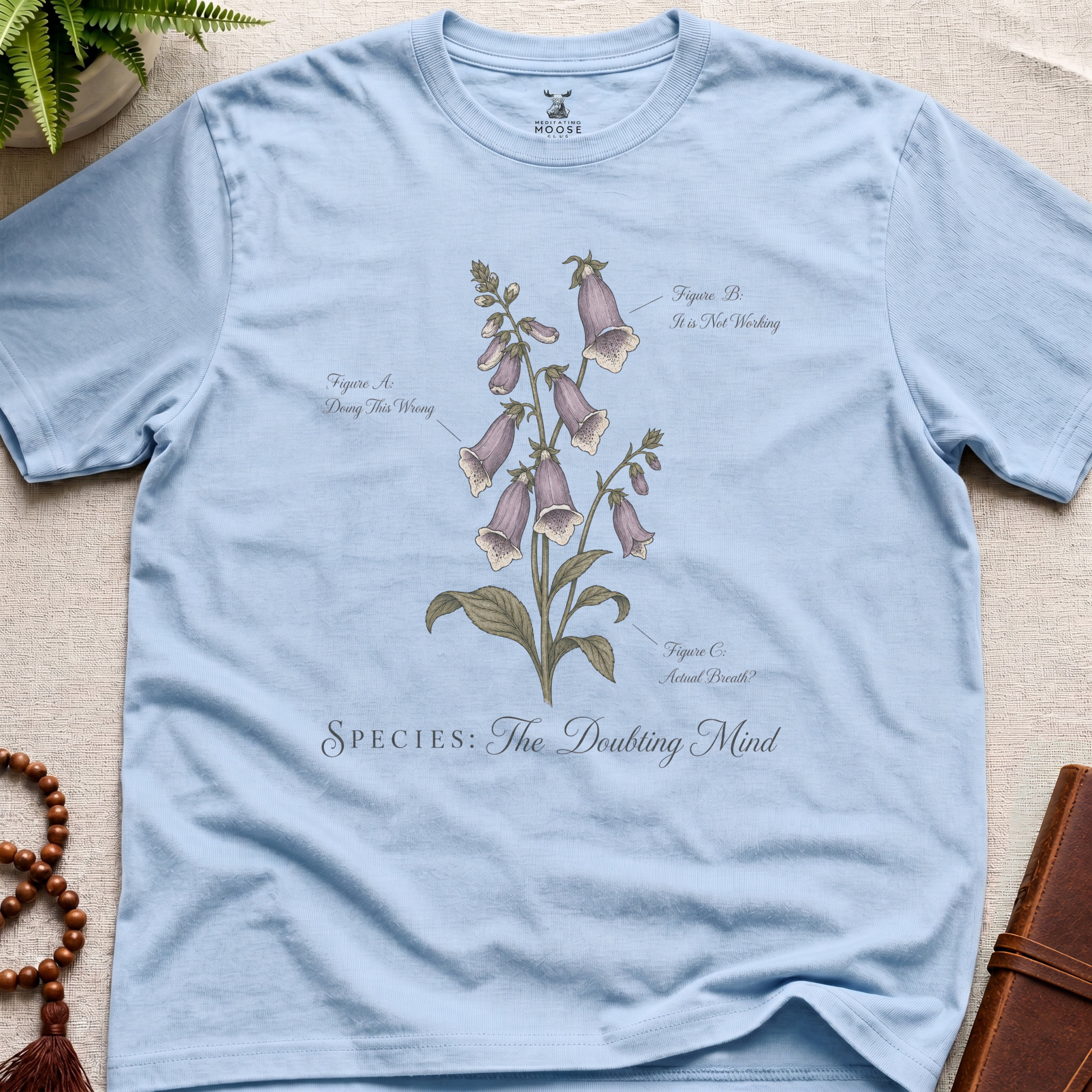 Light blue vintage botanical graphic t-shirt featuring doubting mind natural history illustration