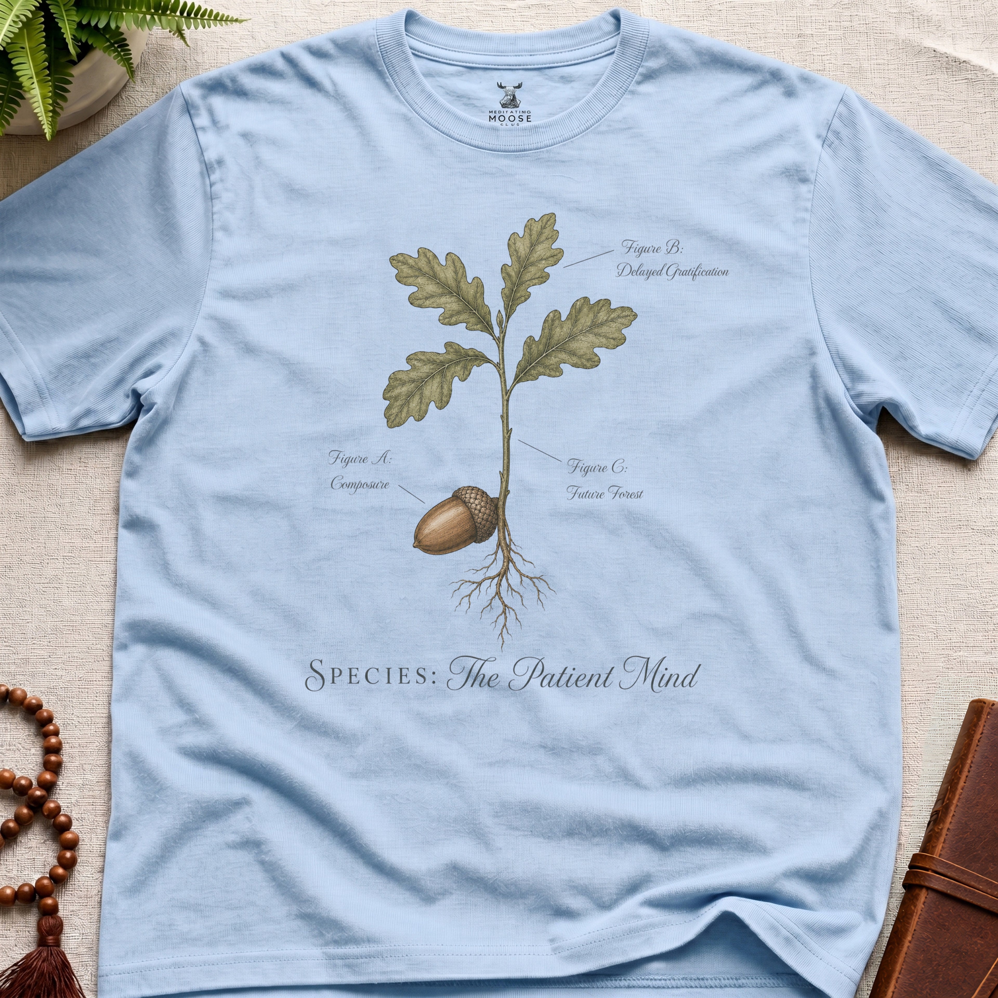 Light blue vintage botanical graphic t-shirt featuring patient mind natural history illustration