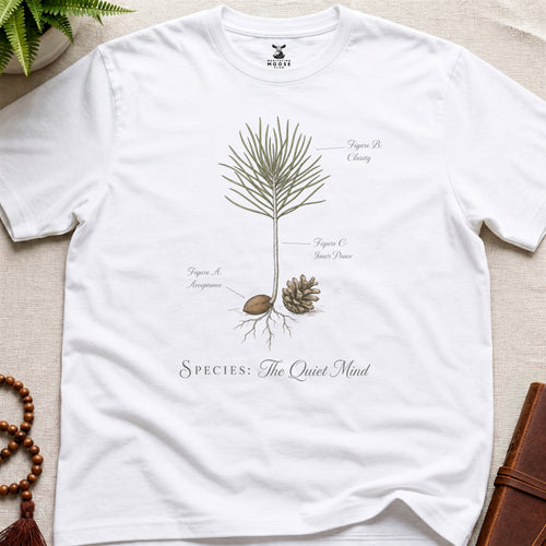 White t-shirt with botanical design and text on a beige surface