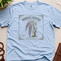 Light blue t-shirt with a vintage-style seed packet design featuring wisteria on a beige surface.