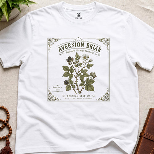 White t-shirt with a graphic design of a plant label on a beige surface.