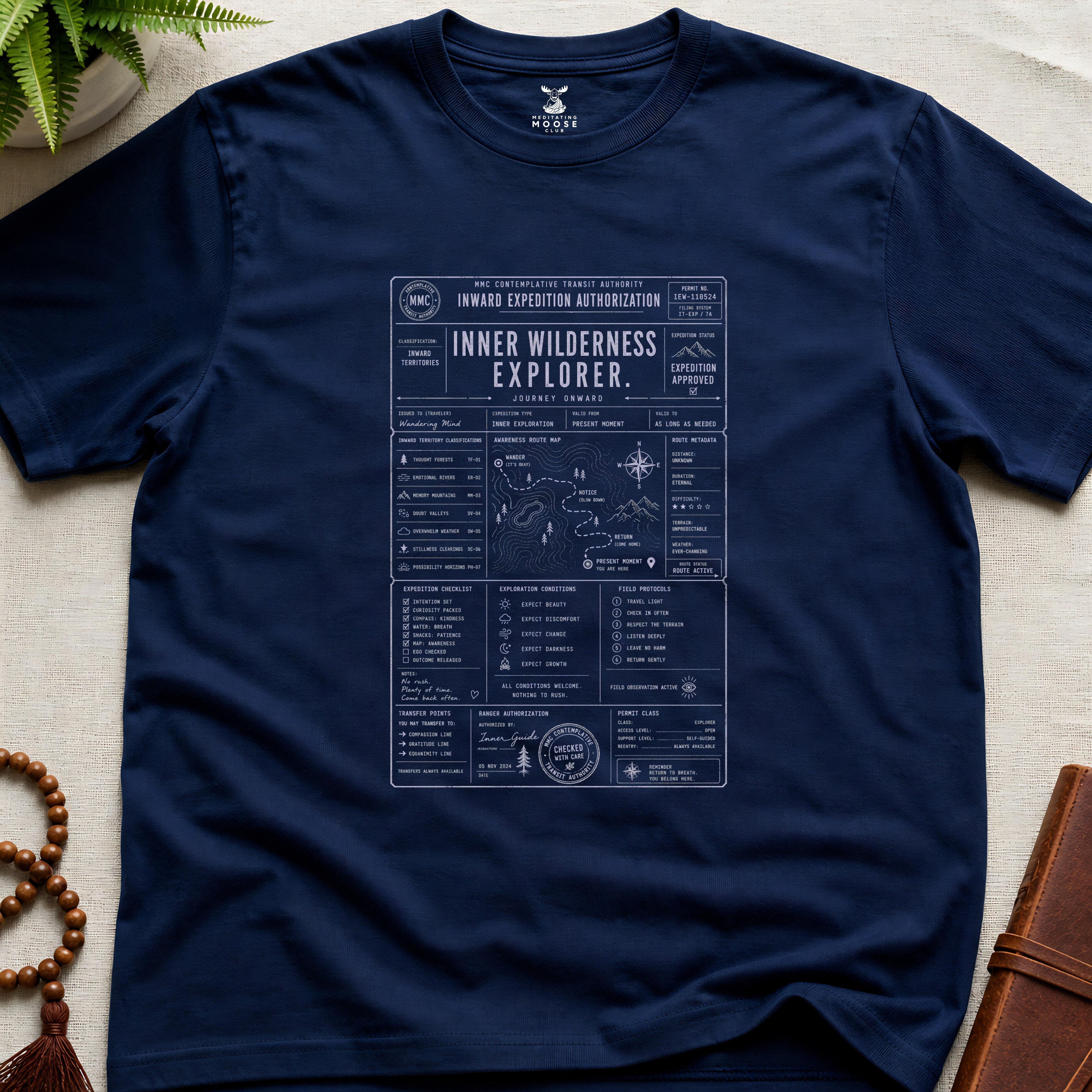 Navy contemplative inward expedition permit t-shirt graphic reading “Inner Wilderness Explorer” with navigation charts and mindfulness field systems.
