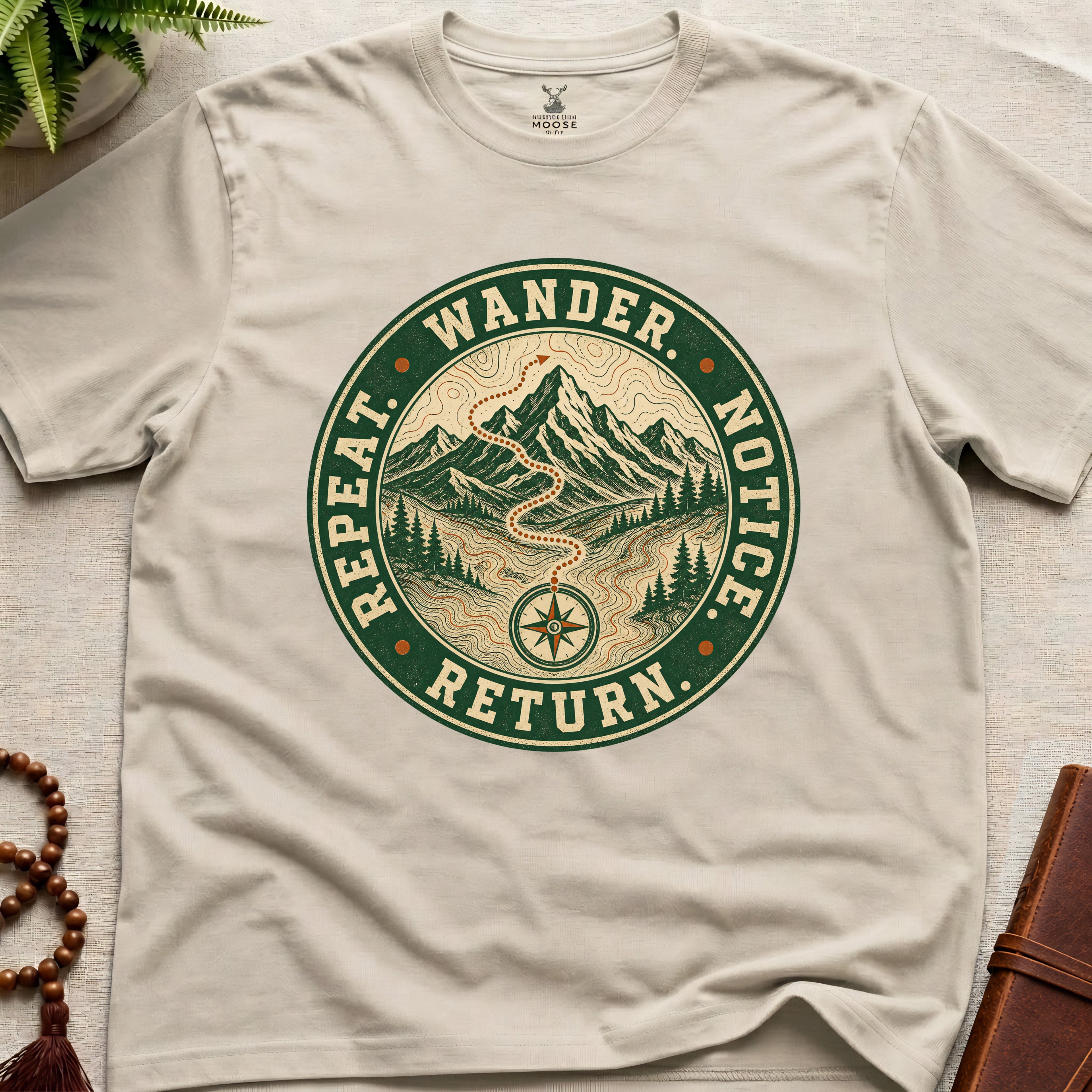 Beige mindfulness t-shirt mockup featuring Wander Notice Return vintage mountain meditation badge graphic