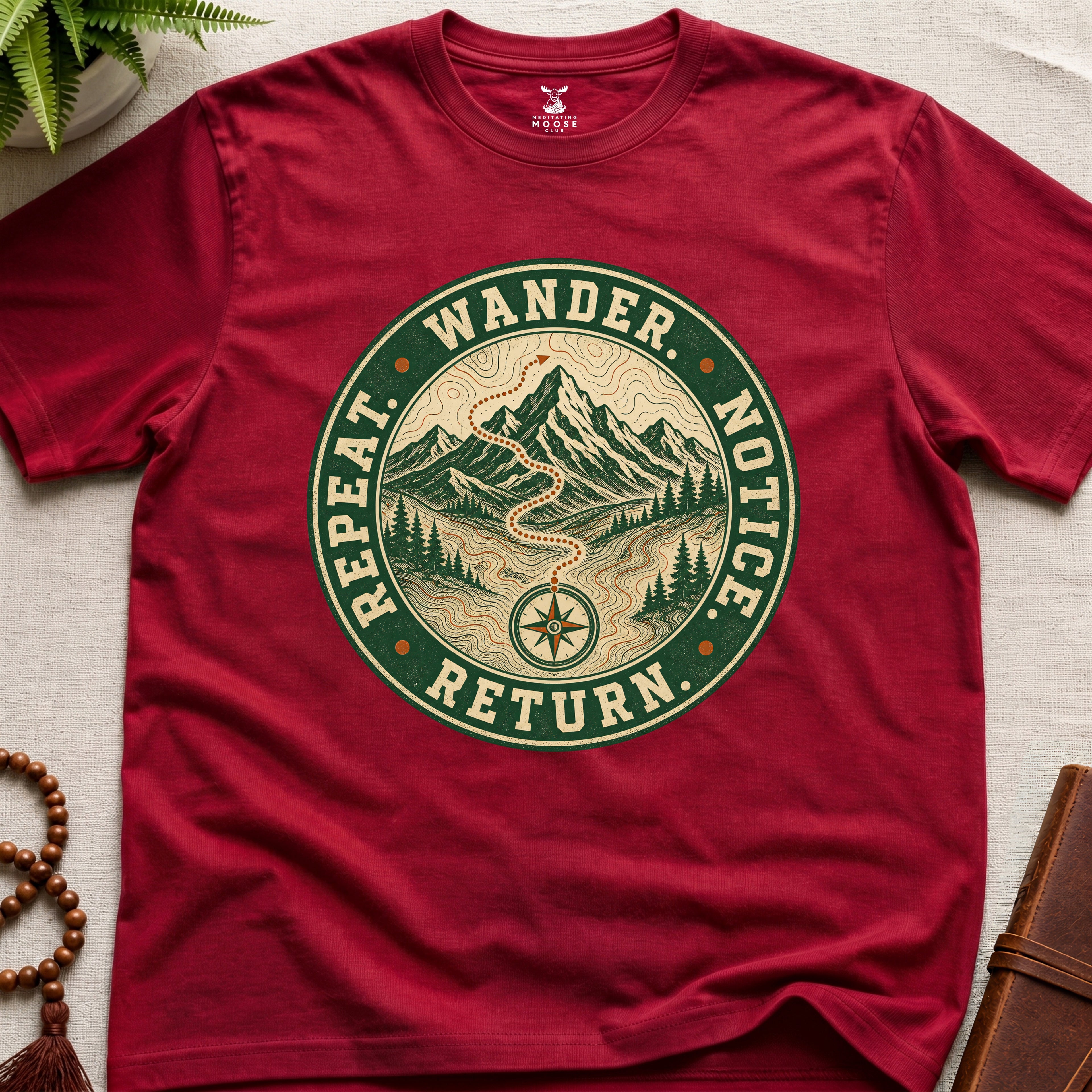 Red mindfulness t-shirt mockup featuring Wander Notice Return vintage mountain meditation badge graphic