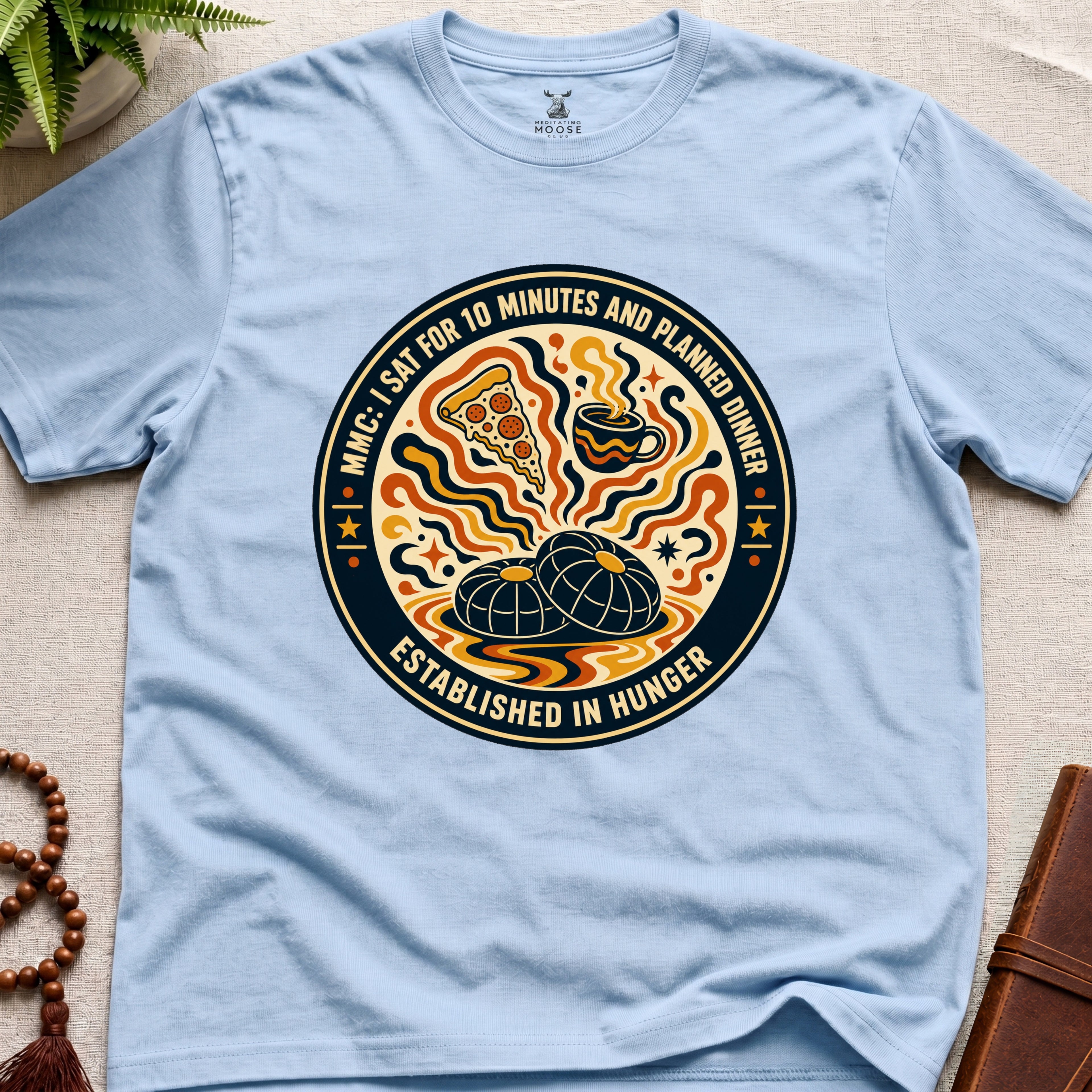 A funny light blue meditation t-shirt with retro hunger badge design featuring pizza coffee and mindfulness humour